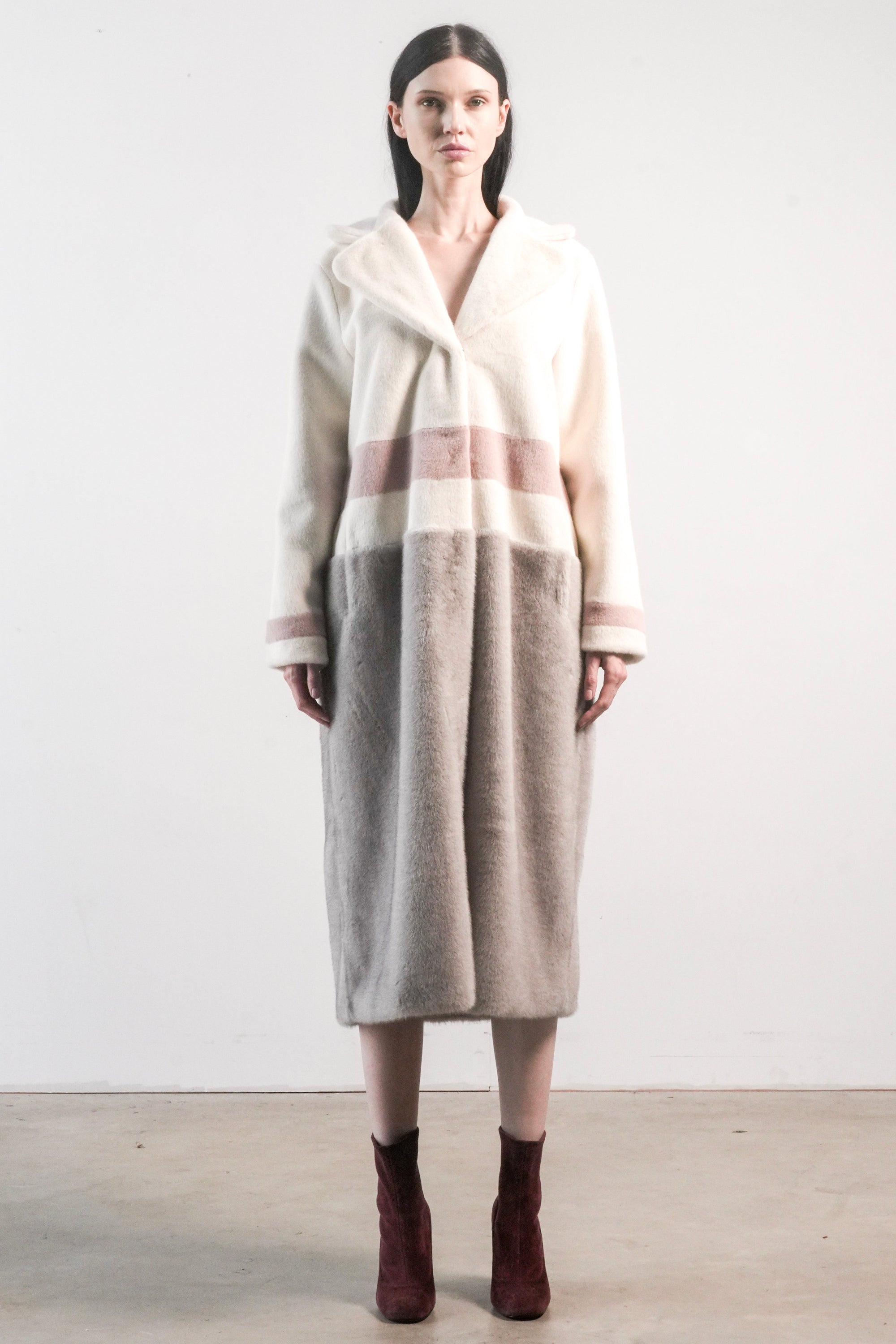A female model wearing a Ajax striped long faux fur jacket with a lapel collar.