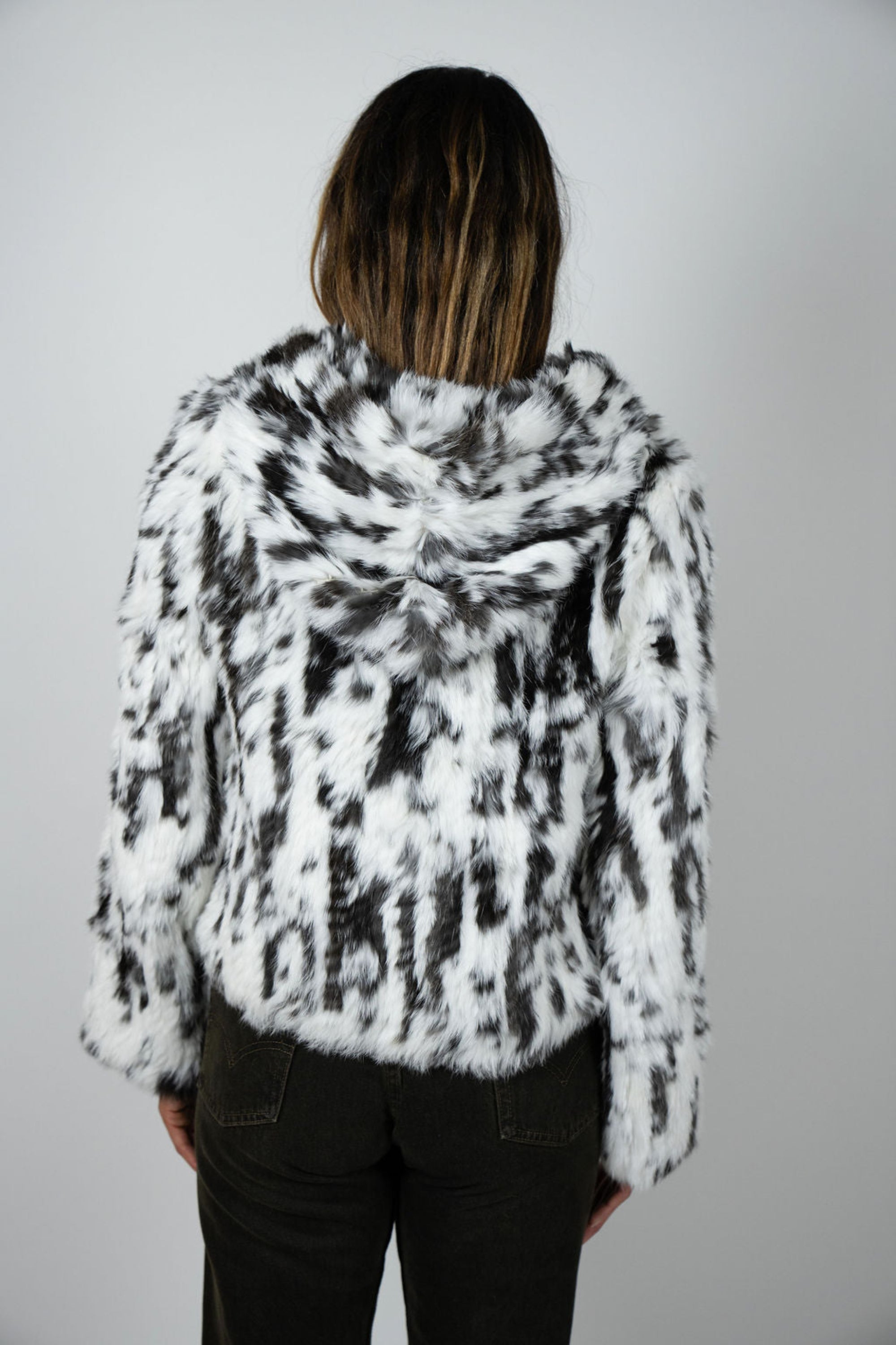 Back view of cropped snow leopard rabbit fur jacket showing full hood and texture detail.