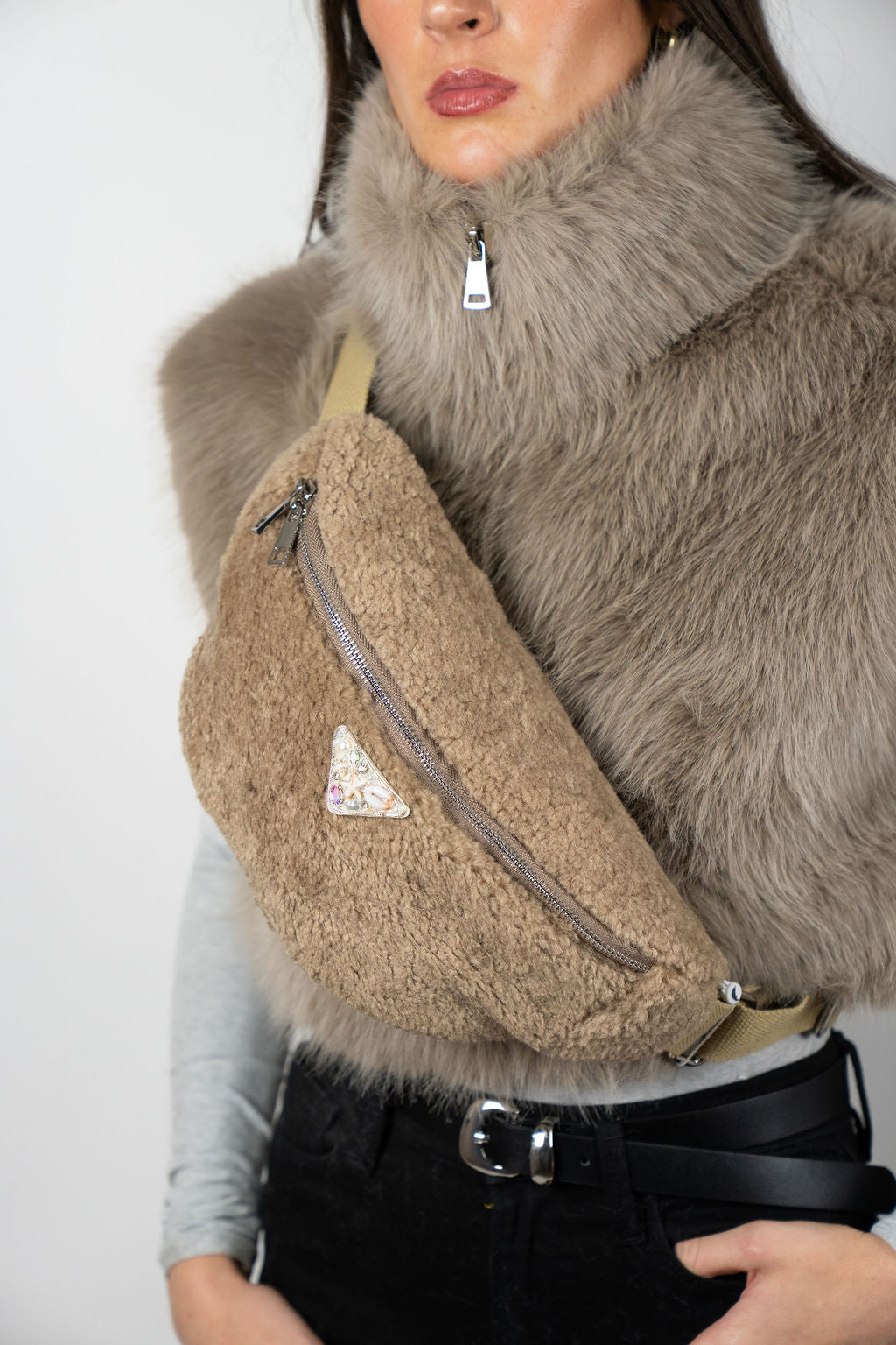 Model wearing the Alpine crossbody bag in Beige by Angel Wings by Lucy, a compact luxury accessory designed for elevated winter and resort wear.