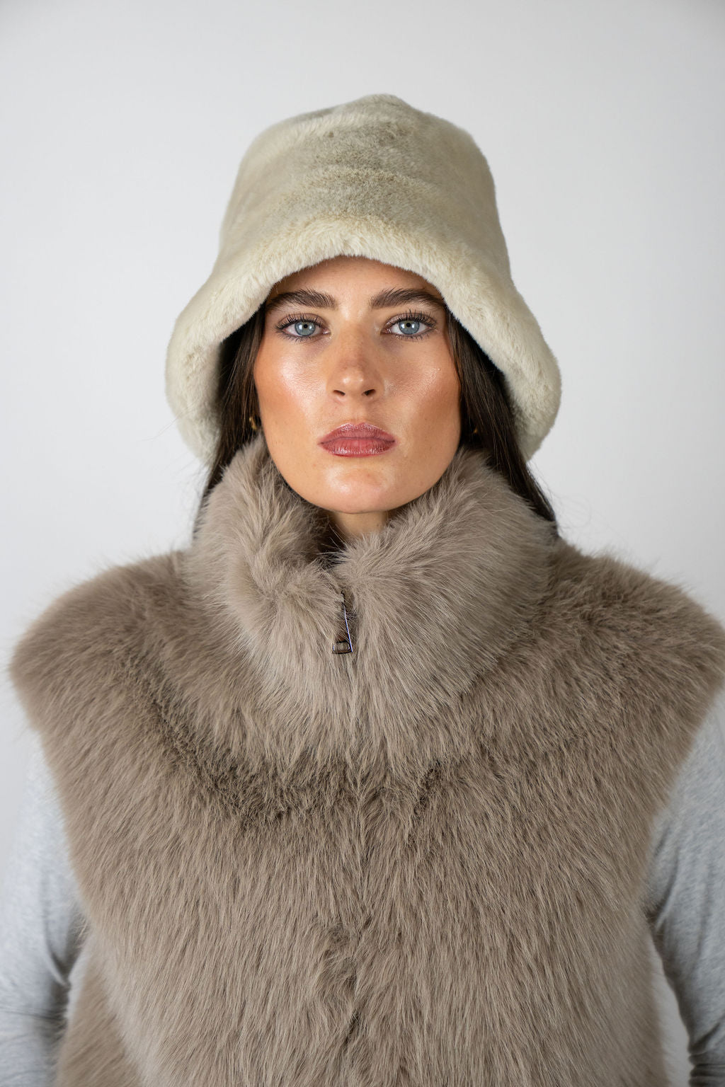 Model wearing the Bucket Hat in Beige by Angel Wings by Lucy, a luxury faux fur accessory designed for elevated winter styling.