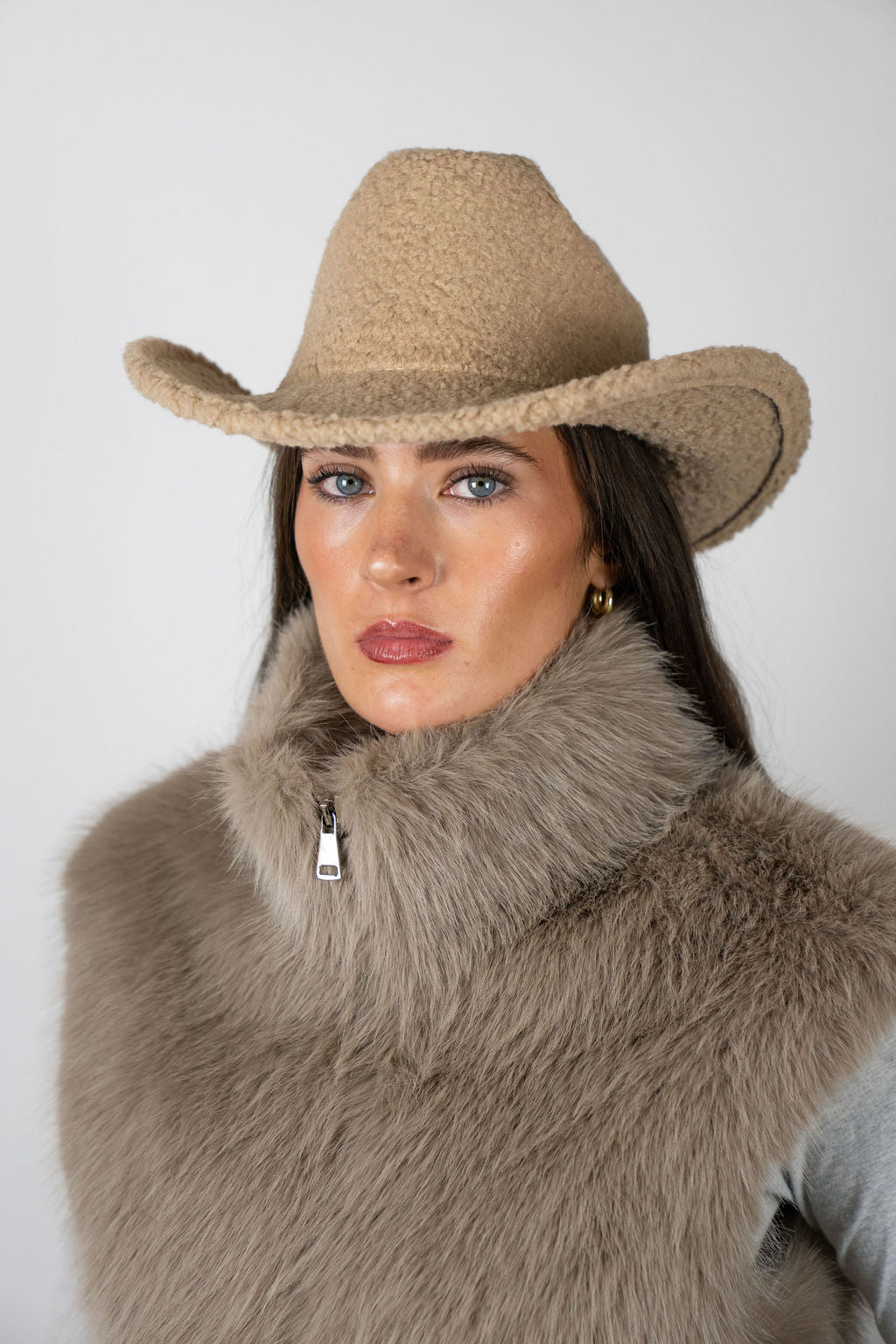 Model wearing the Cowboy Hat in Beige by Angel Wings by Lucy, styled with a faux fur vest for elevated western-inspired winter dressing.