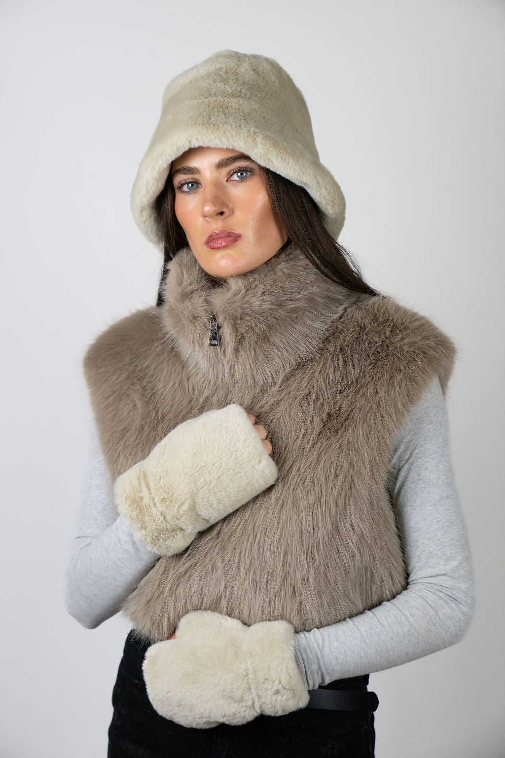 Model wearing fingerless faux fur gloves in Beige by Angel Wings by Lucy, styled with a faux fur vest for elevated winter layering.