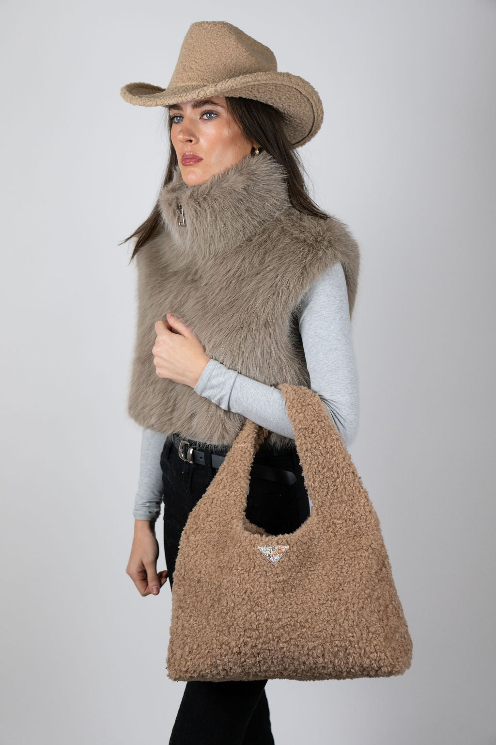 Model wearing The Cloud Club bag in Beige by Angel Wings by Lucy, a plush luxury handbag designed for elevated winter and resort styling.