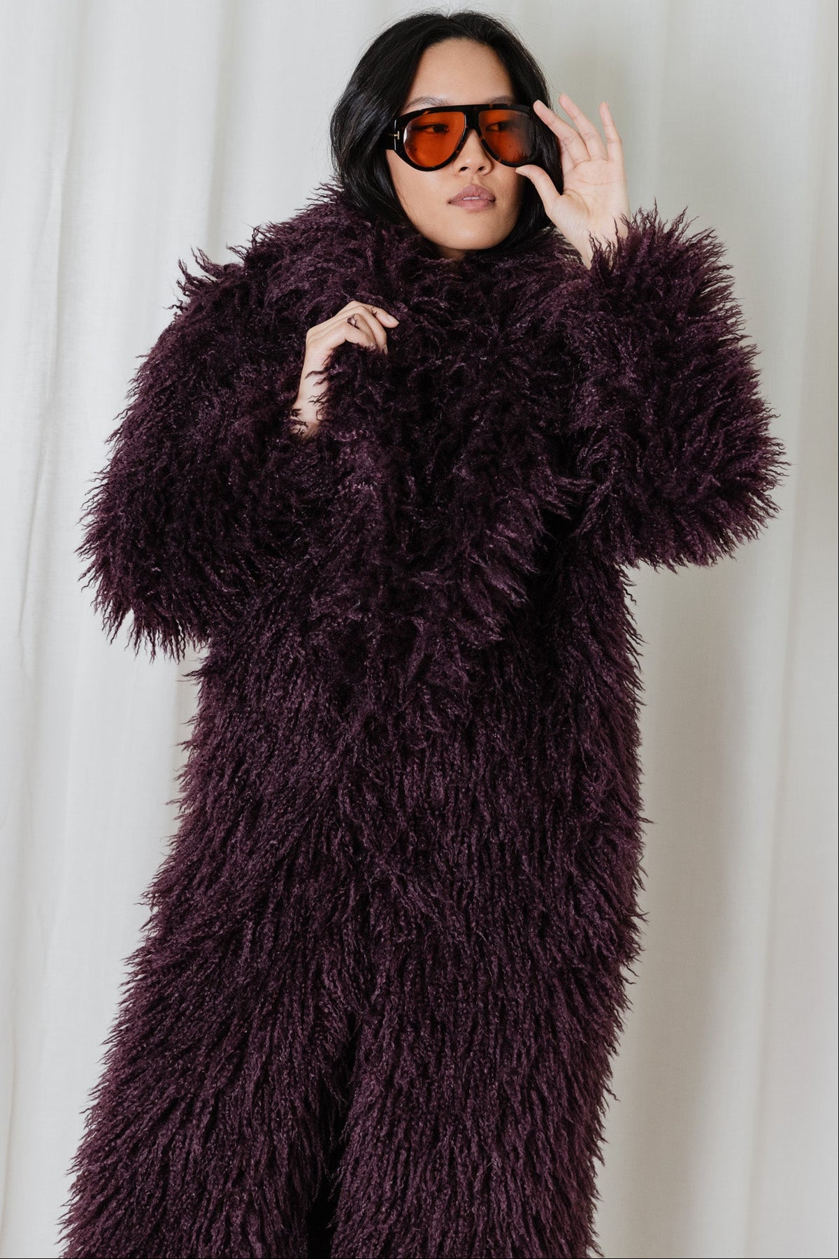 Cropped view of the Angel Wings Yeti Coat in Bordeaux, a long shaggy faux-fur statement coat.