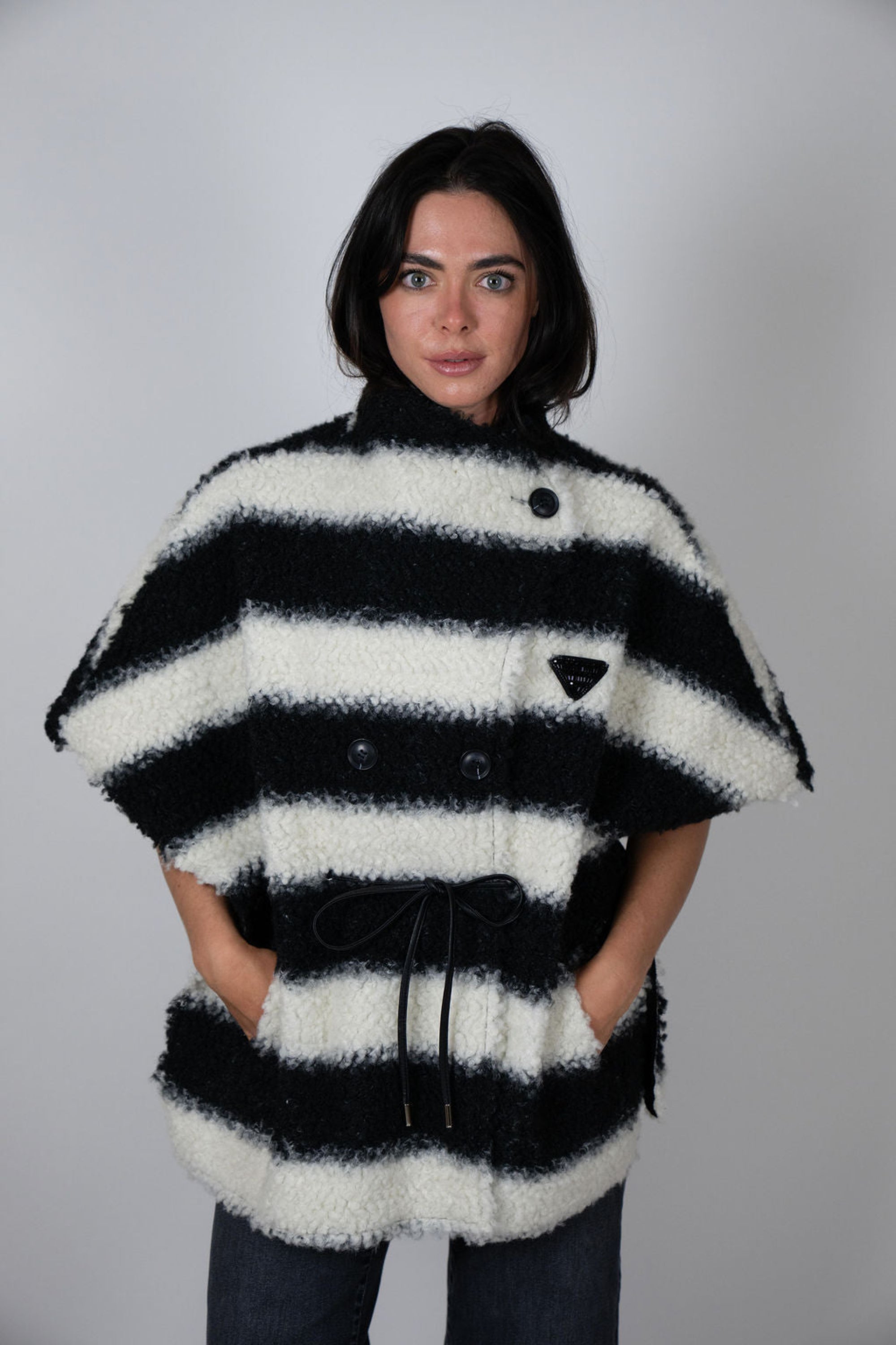 Angel Wings by Lucy black and white striped wool cape, oversized with short sleeves, buttons and drawstring waist, shown on model from front.