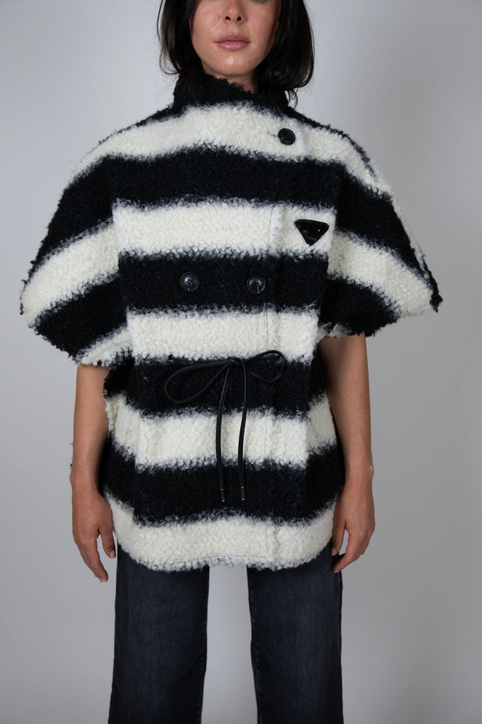 Angel Wings by Lucy black and white striped wool cape, oversized with short sleeves, buttons and drawstring waist, shown on model from front.