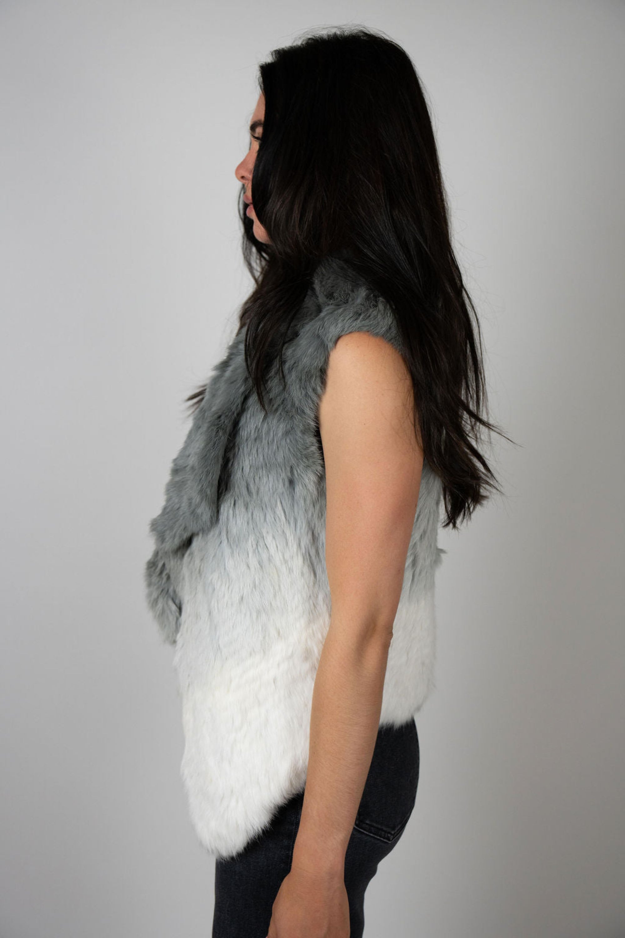 Angel Wings by Lucy rabbit fur vest in pale grey ombré, sleeveless and open-front, worn by model facing side.