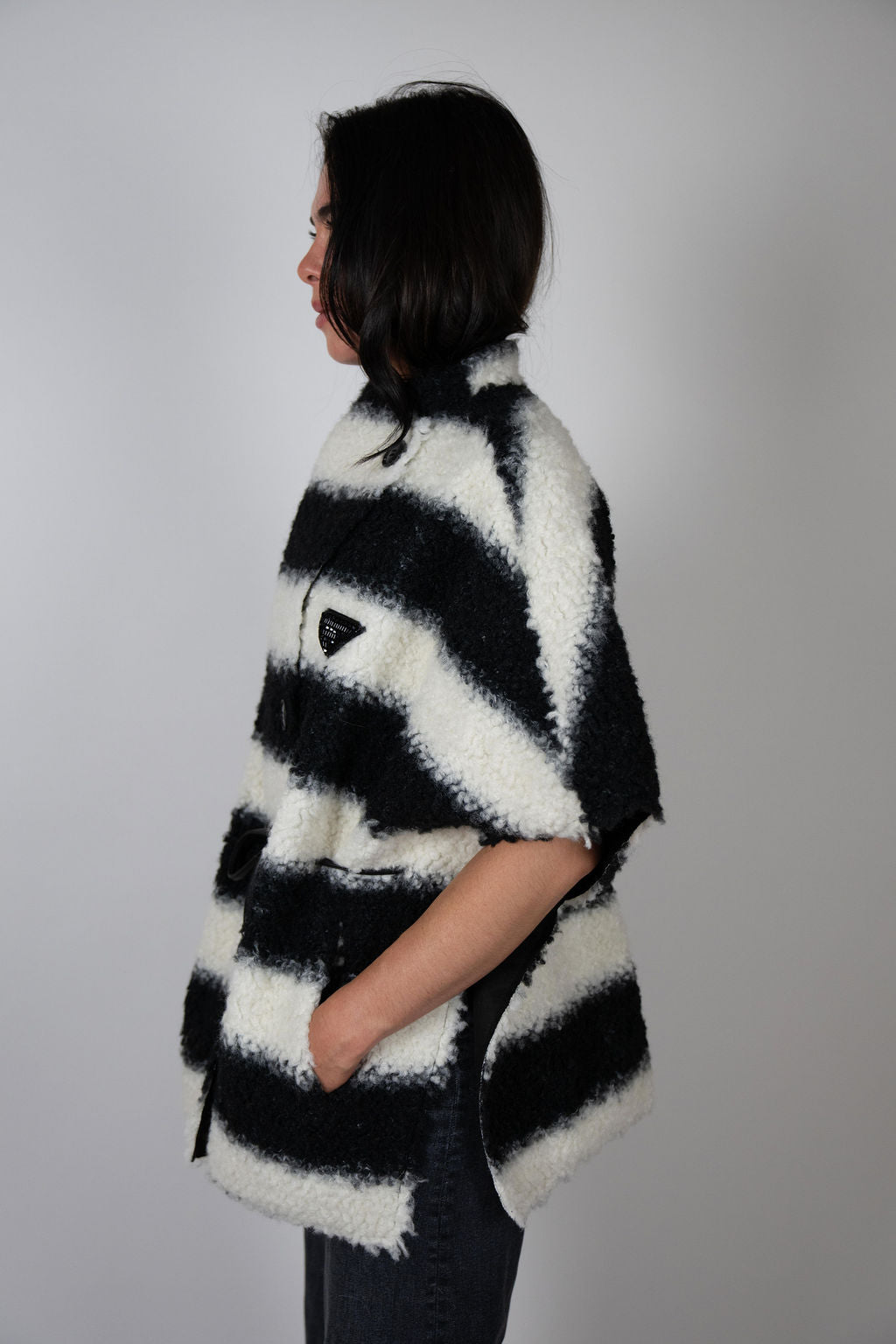 Angel Wings by Lucy black and white striped wool cape, oversized with short sleeves, buttons and drawstring waist, shown on model from side.