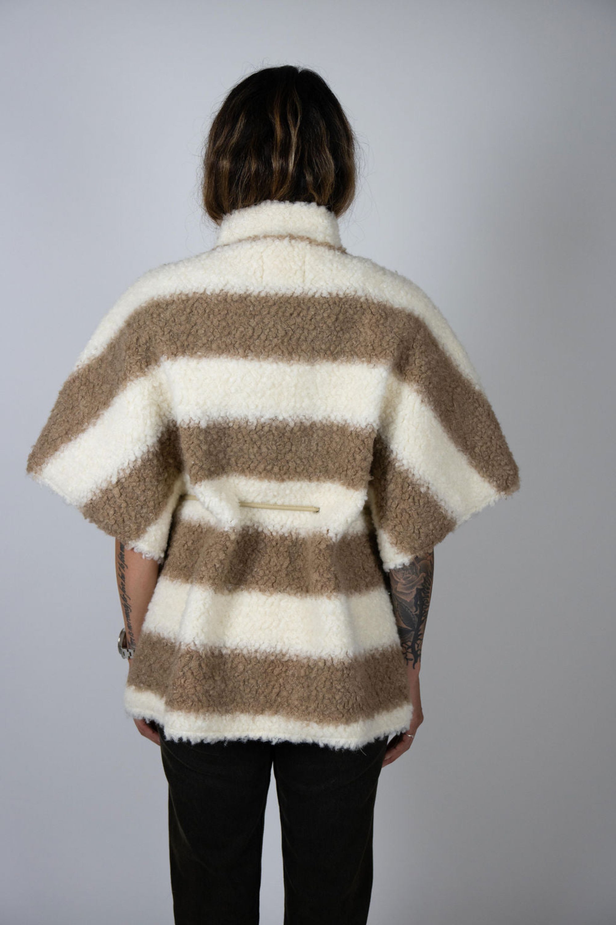 Angel Wings by Lucy wool cape in beige and ivory stripe, oversized with short sleeves, drawstring waist, and buttons, shown on model back view