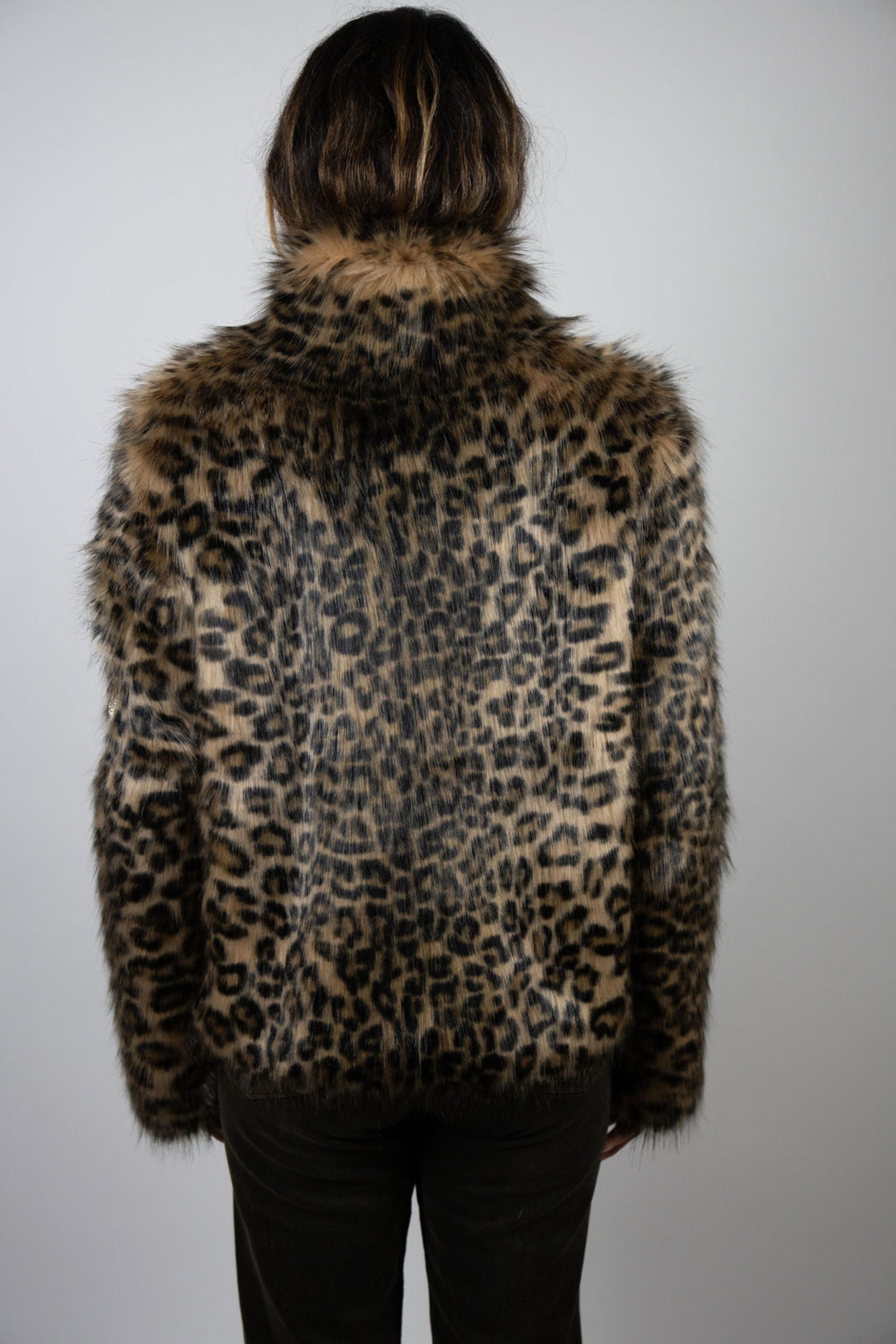 Angel Wings by Lucy cropped leopard faux fur jacket with skull detail on sleeve, high collar, and side pockets, worn by model from back angle.