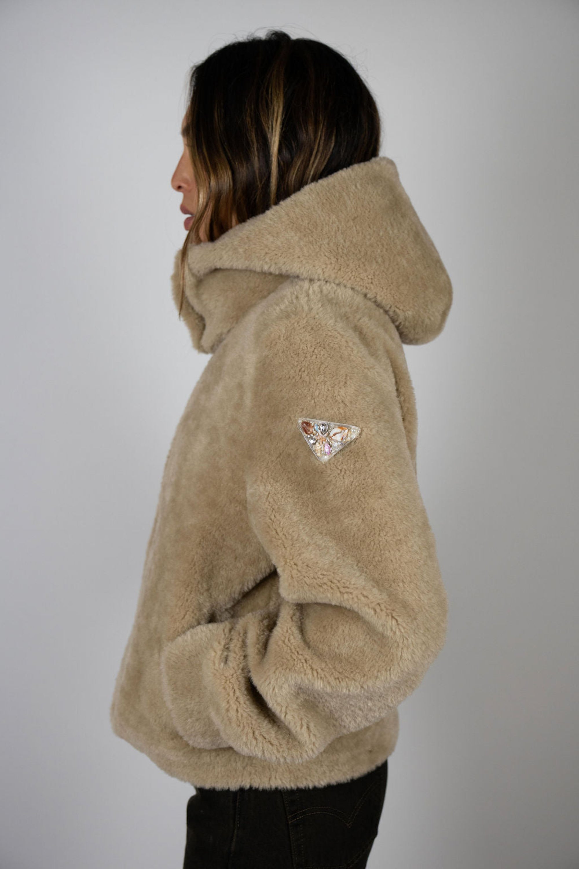 Side profile of model in Angel Wings by Lucy Slope Room Faux Fur Bomber – triangle logo on sleeve, luxury winter jacket