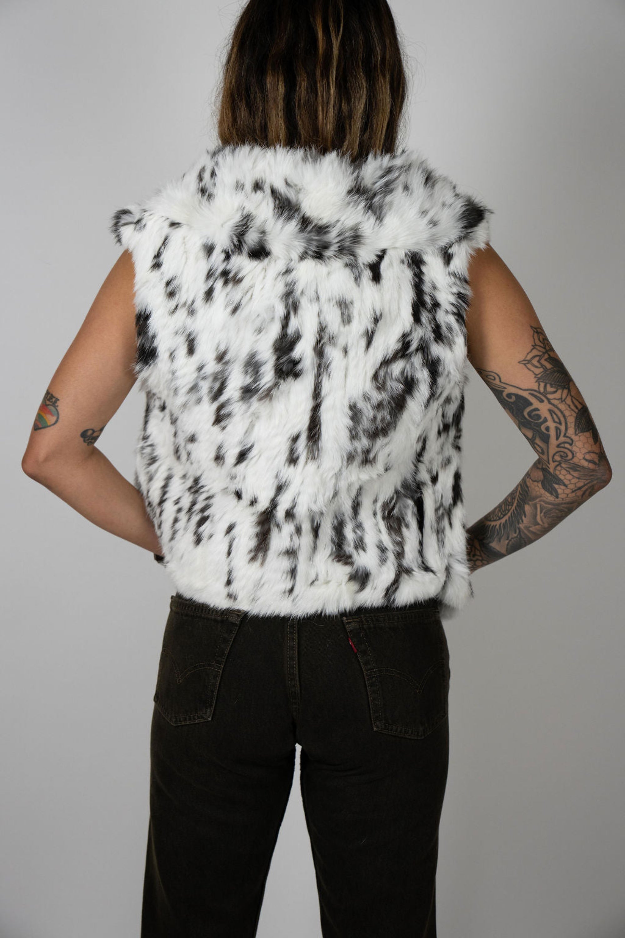 Angel Wings by Lucy rabbit fur vest in snow leopard print, sleeveless with high collar, shown on model from back angle.