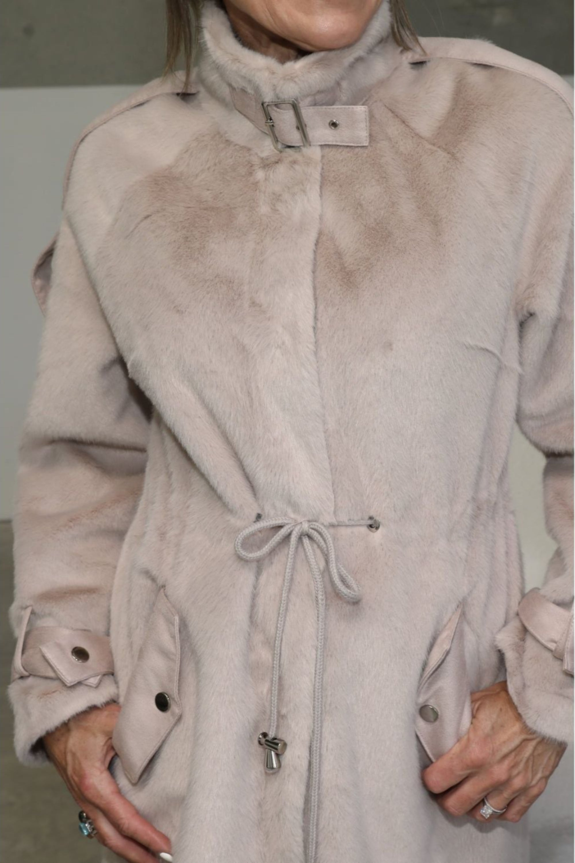 Side view of woman in lilac faux fur jacket with drawstring waist and buckle collar — limited edition Chica Chica style.