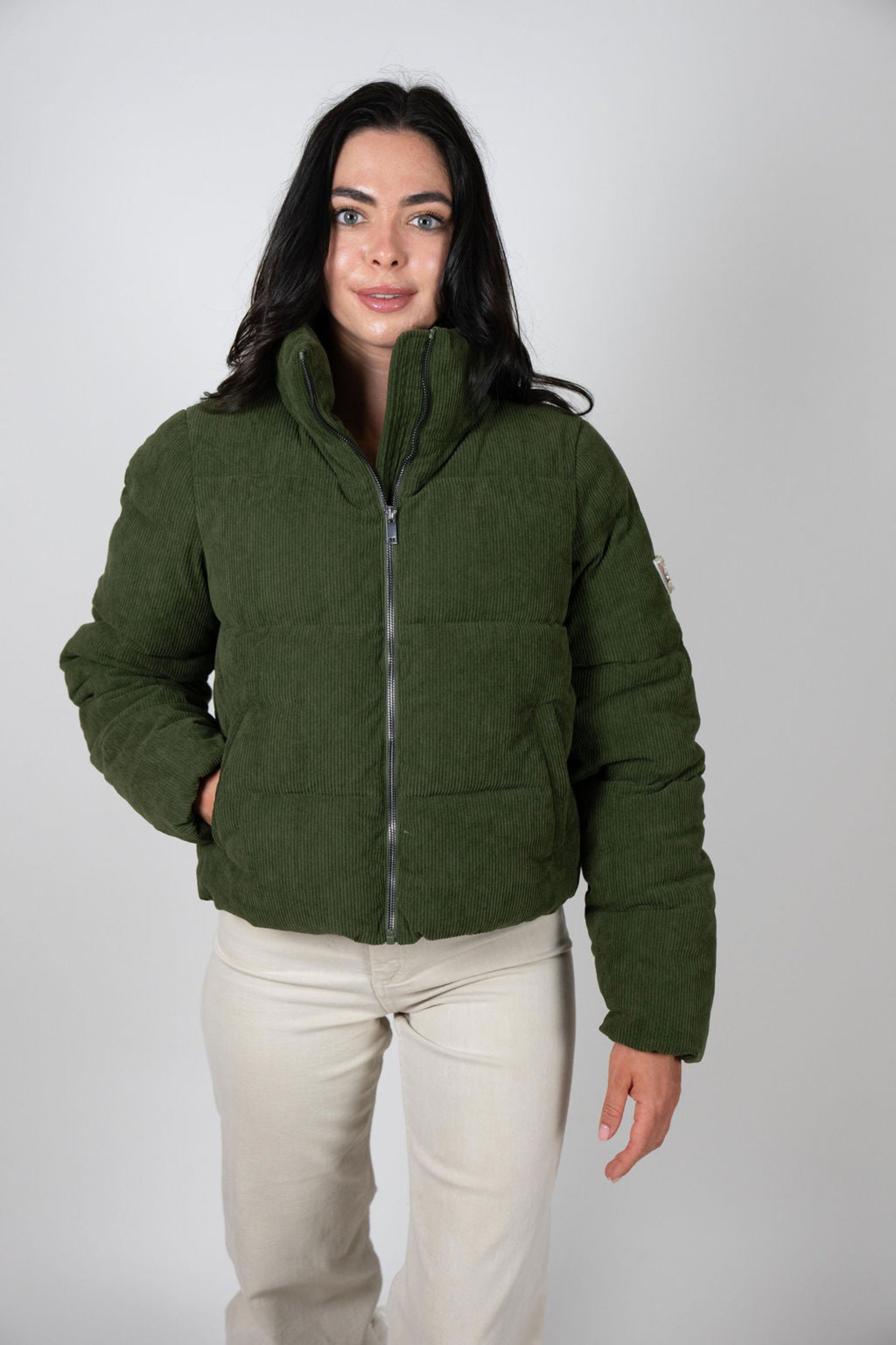 Woman wearing the Angel Wings Sundeck Jacket in olive green with cream pants, facing forward