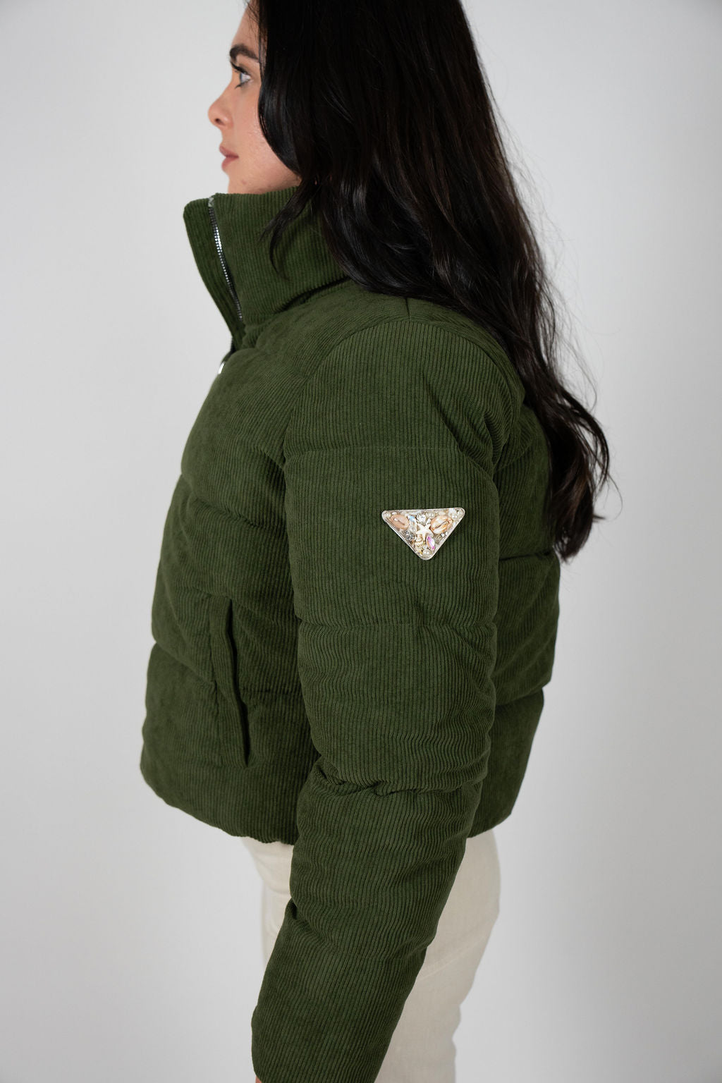 Side view of the Angel Wings Sundeck Jacket in olive showing the embellished triangle patch