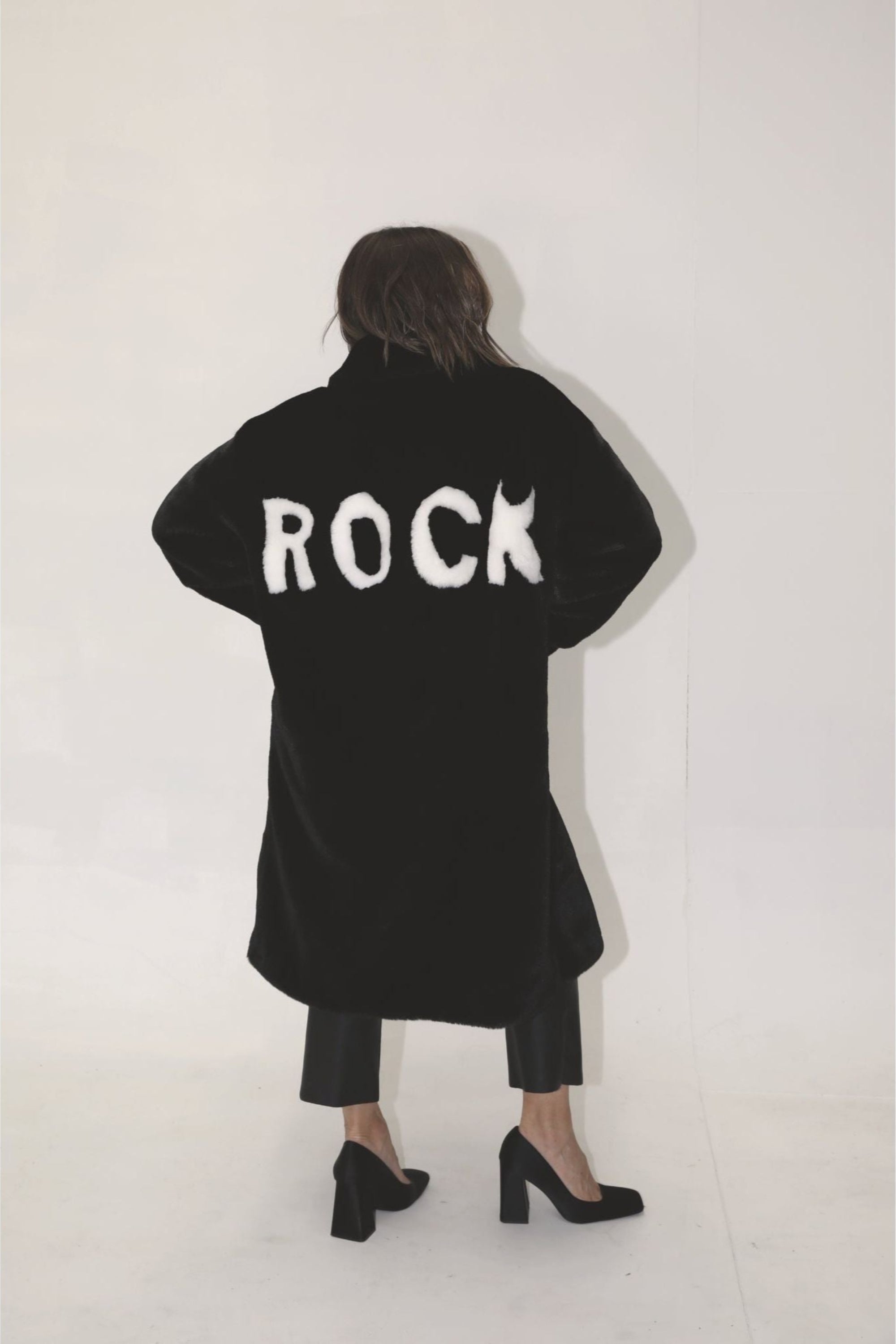 Back view of black faux fur jacket with bold white “ROCK” lettering — from the Mr. Greys collection.