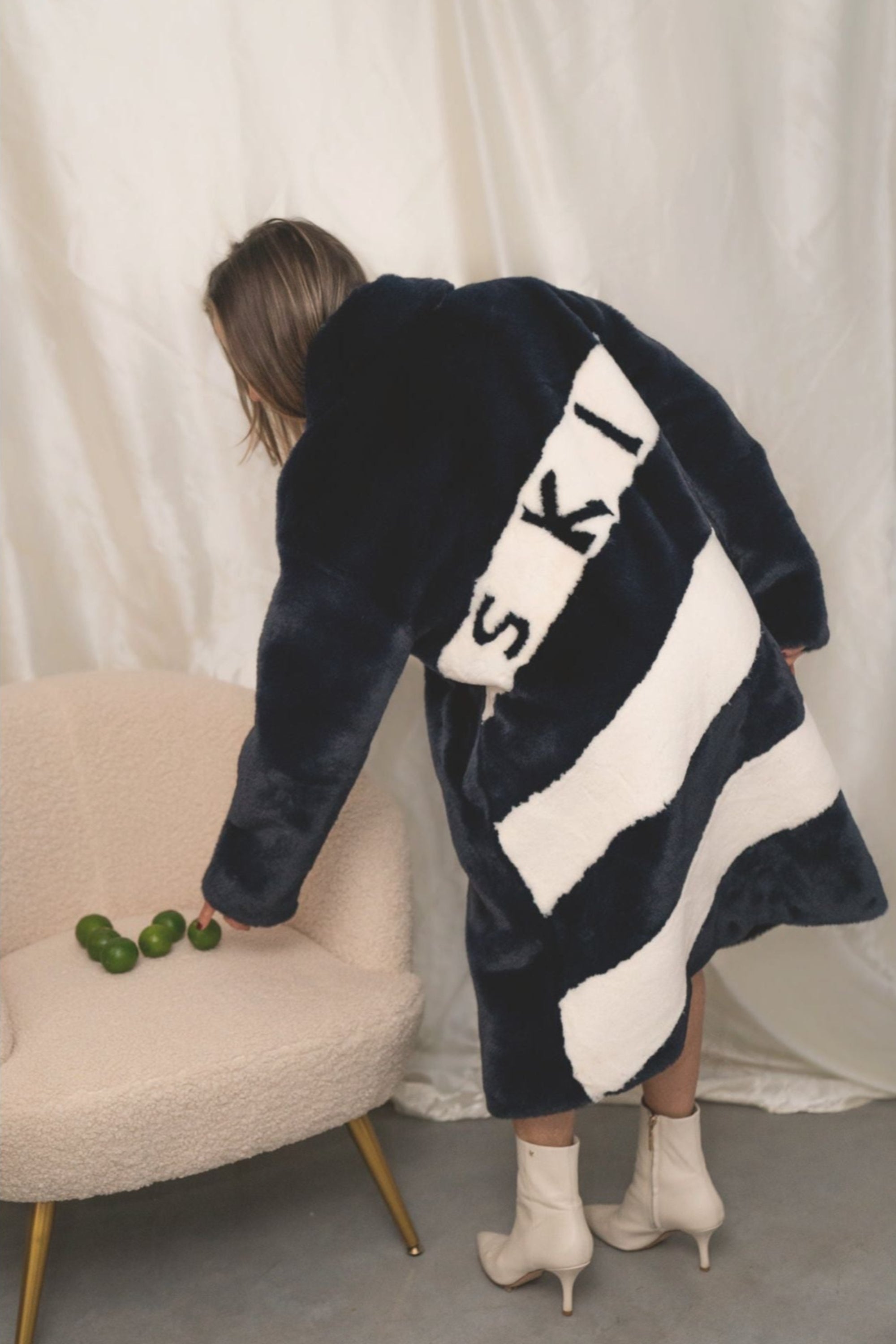 Back view of navy faux fur jacket with bold white diagonal stripes and “SKI” lettering — from the Mr. Greys collection.