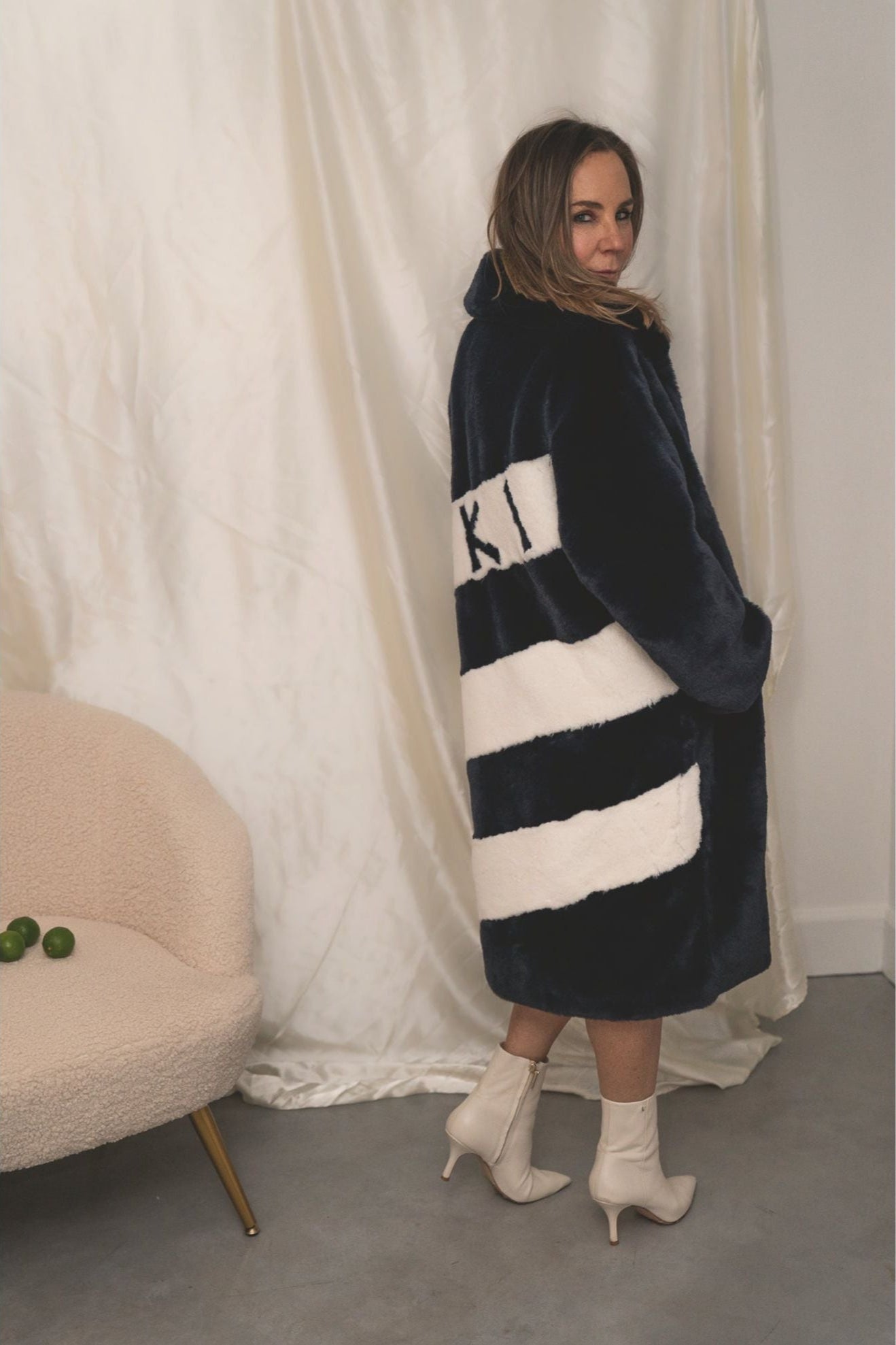 Back view of navy faux fur jacket with bold white diagonal stripes and “SKI” lettering — from the Mr. Greys collection.