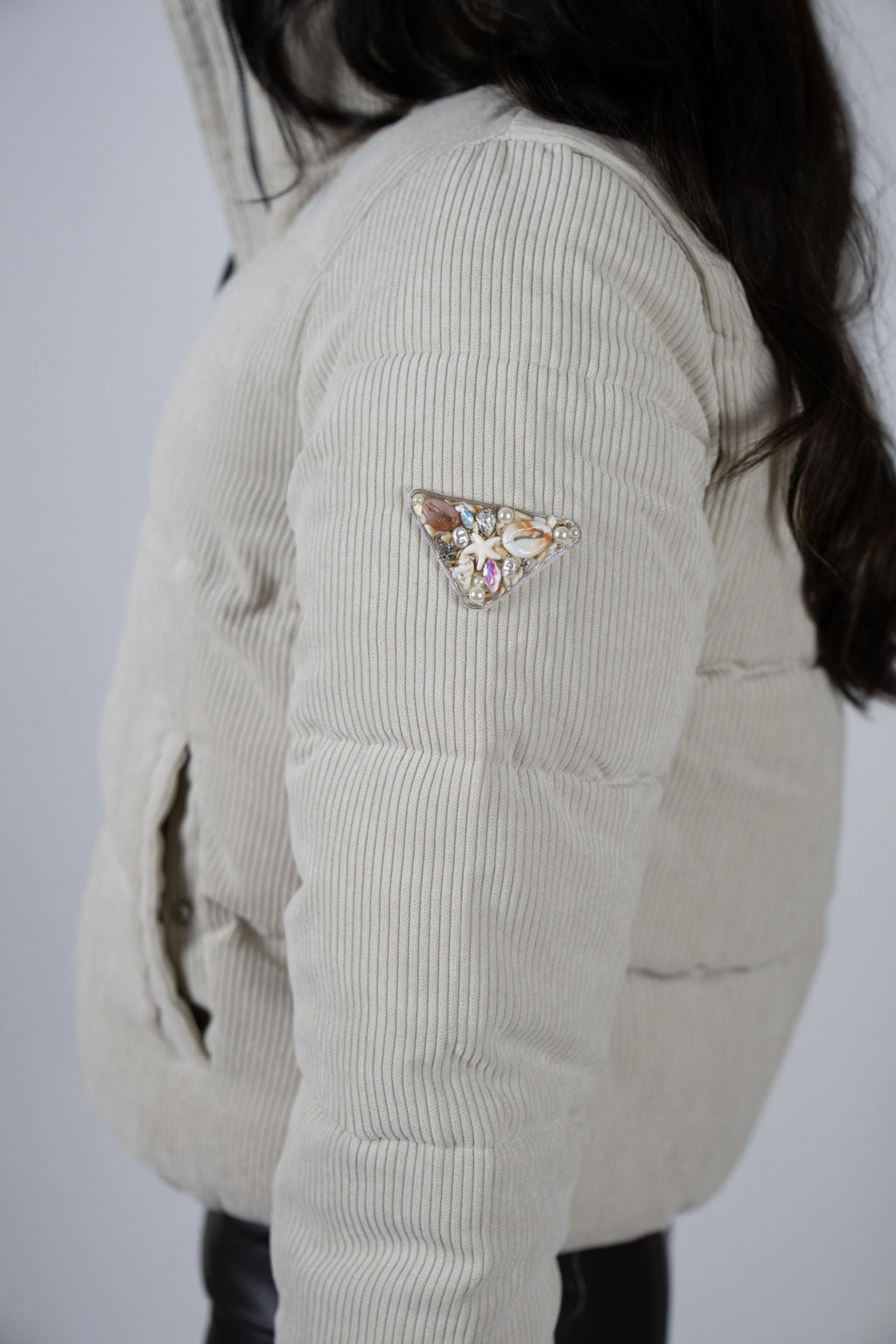 Close-up of embellished logo patch on the sleeve of the Angel Wings Sundeck Jacket.
