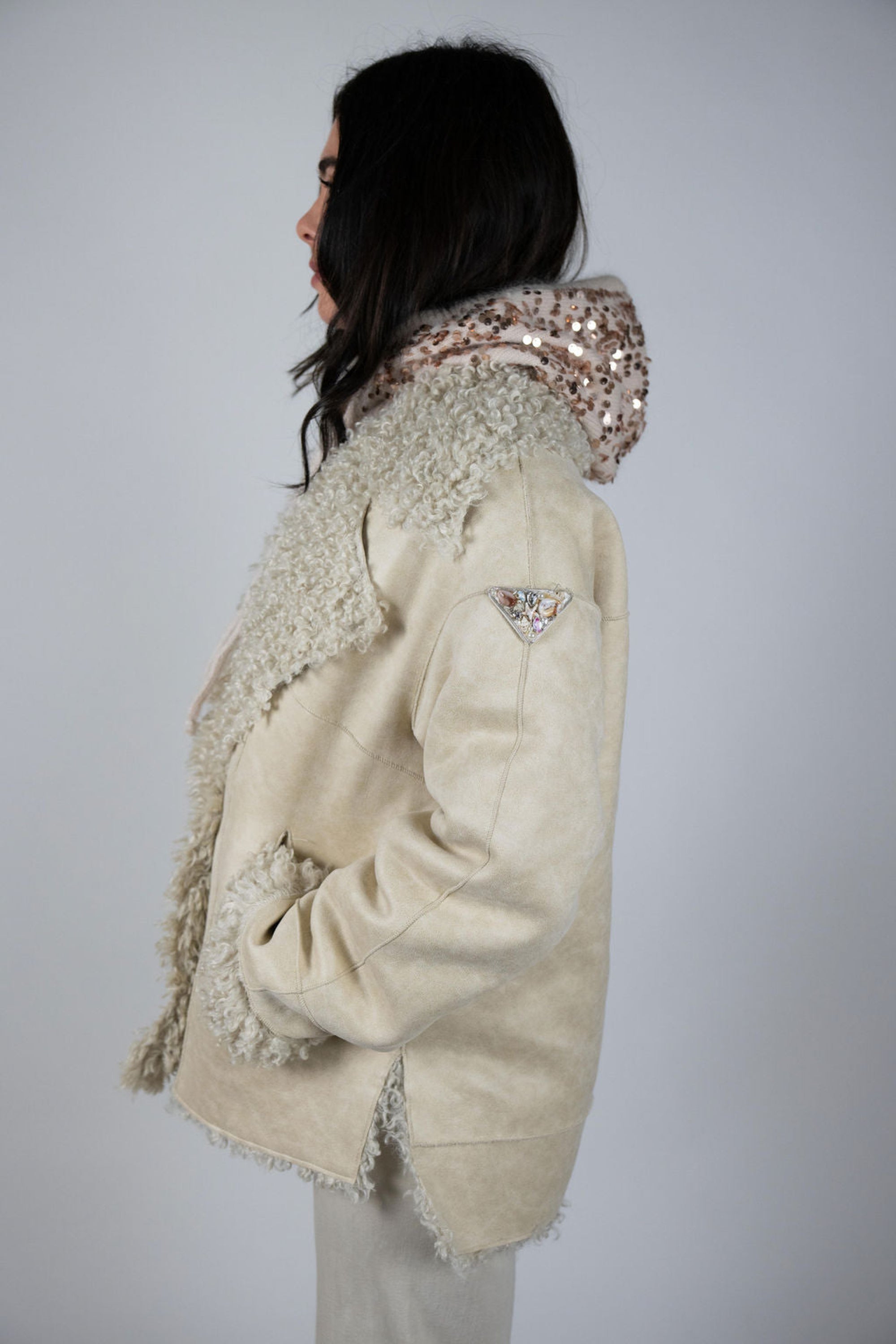 The model demonstrates the jacket’s drape and oversized fit from a side angle, highlighting its volume and cozy, layered styling.
