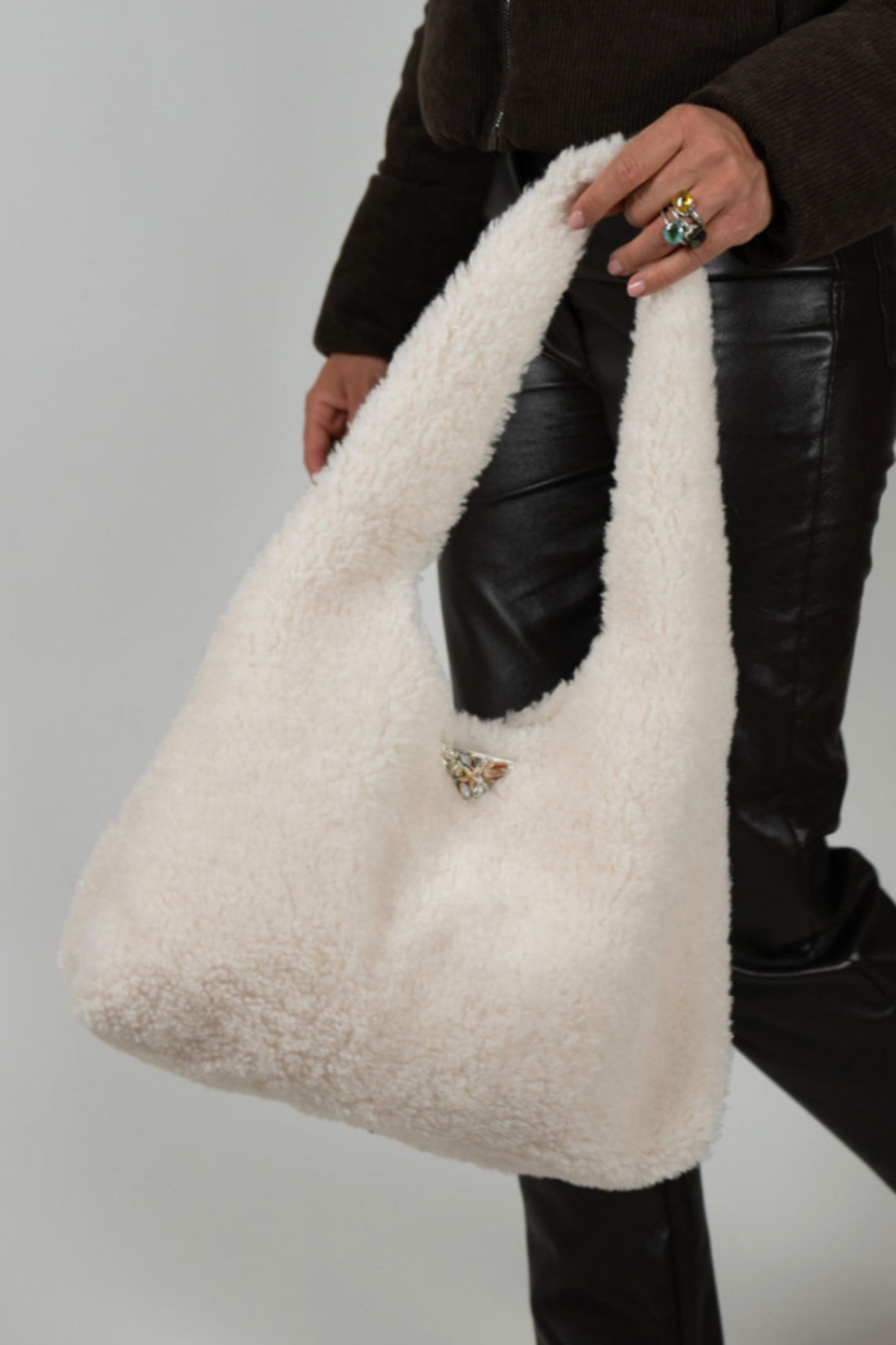 Cream faux shearling handbag with wide strap, triangle emblem, and single clasp closure – Angel Wings by Lucy