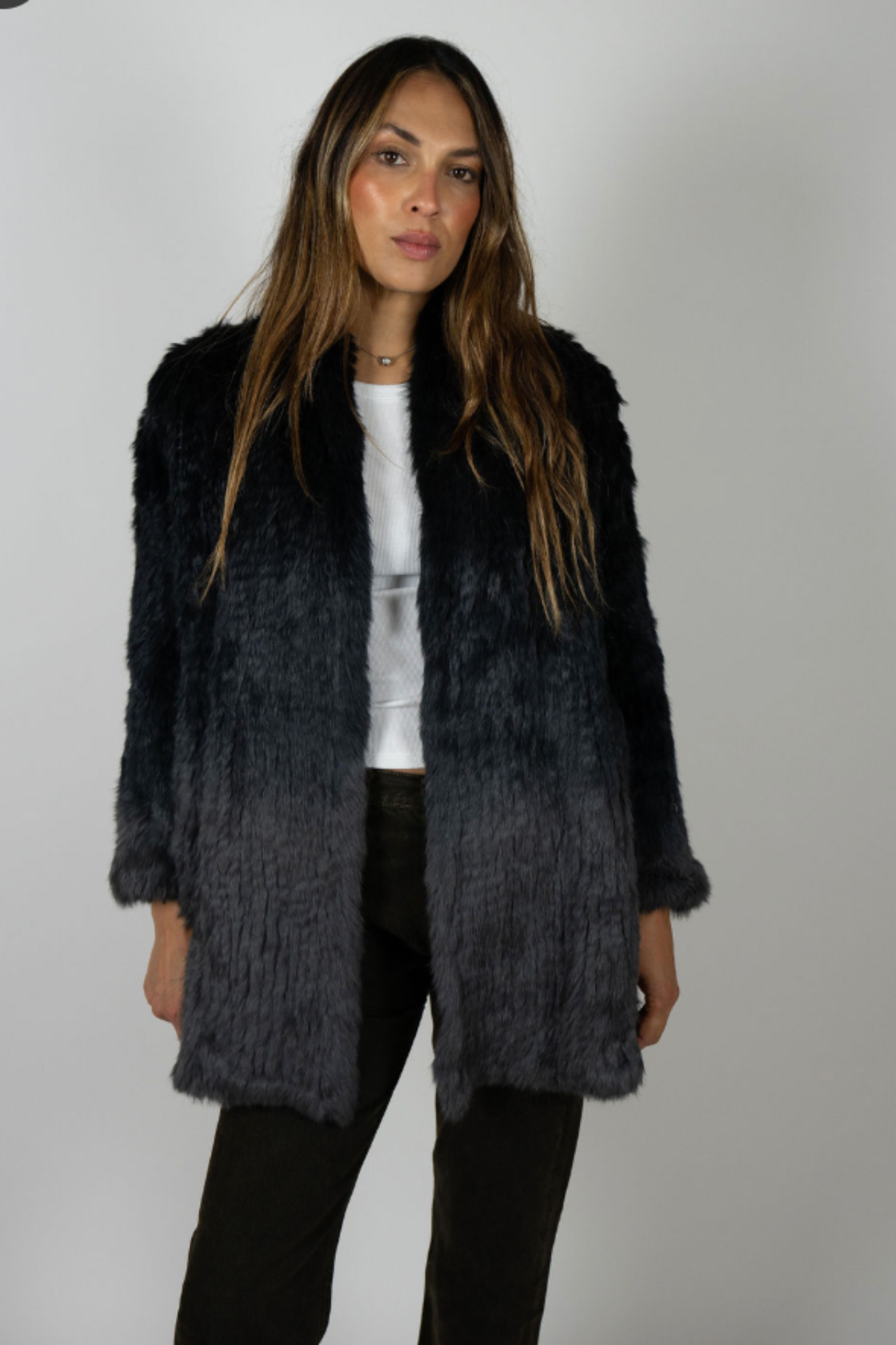 Full body front view of model in Rabbit Dip Dye Black Charcoal fur coat with hands in pockets