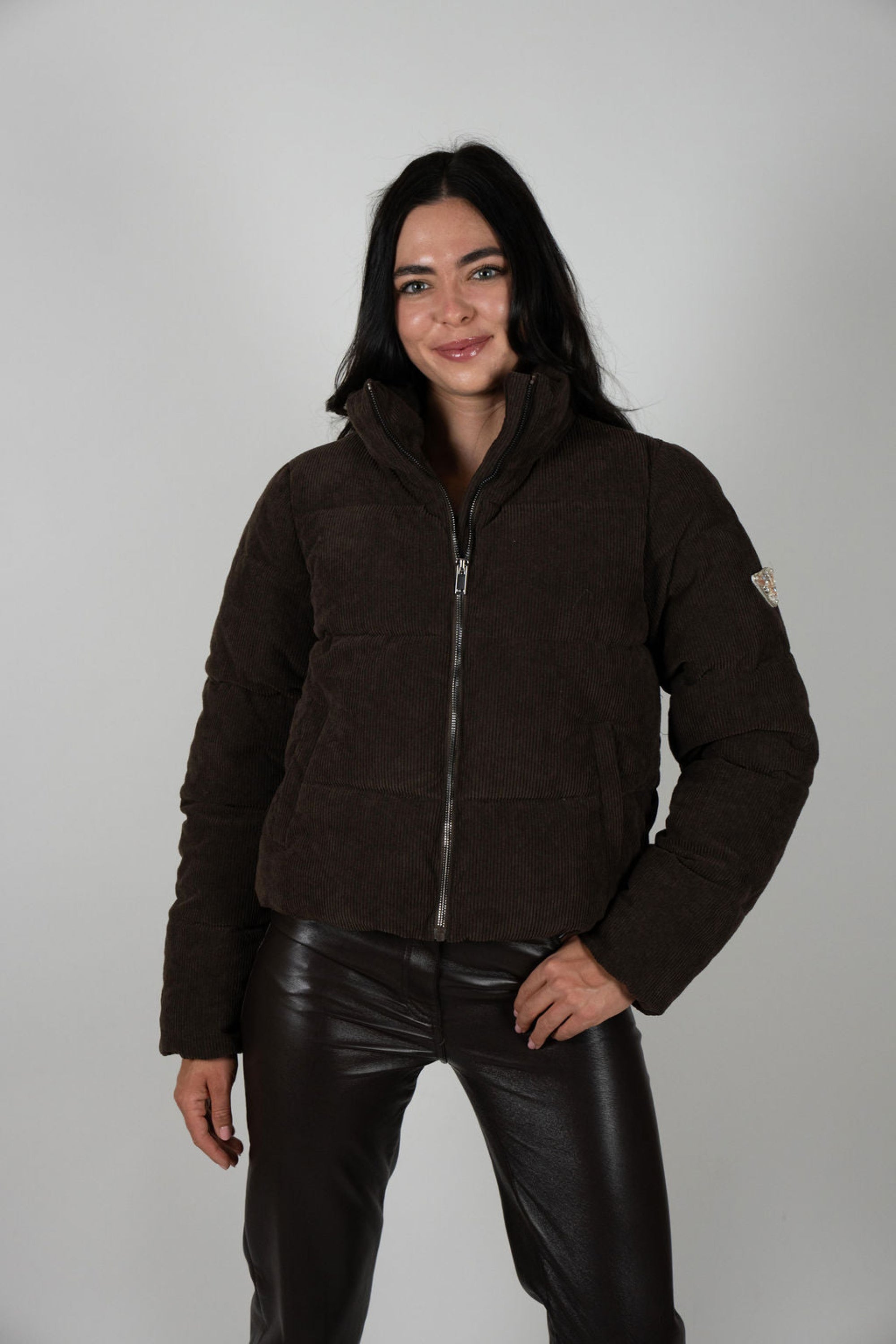 Woman in chocolate cord Angel Wings Sundeck Jacket with one hand in pocket, standing confidently