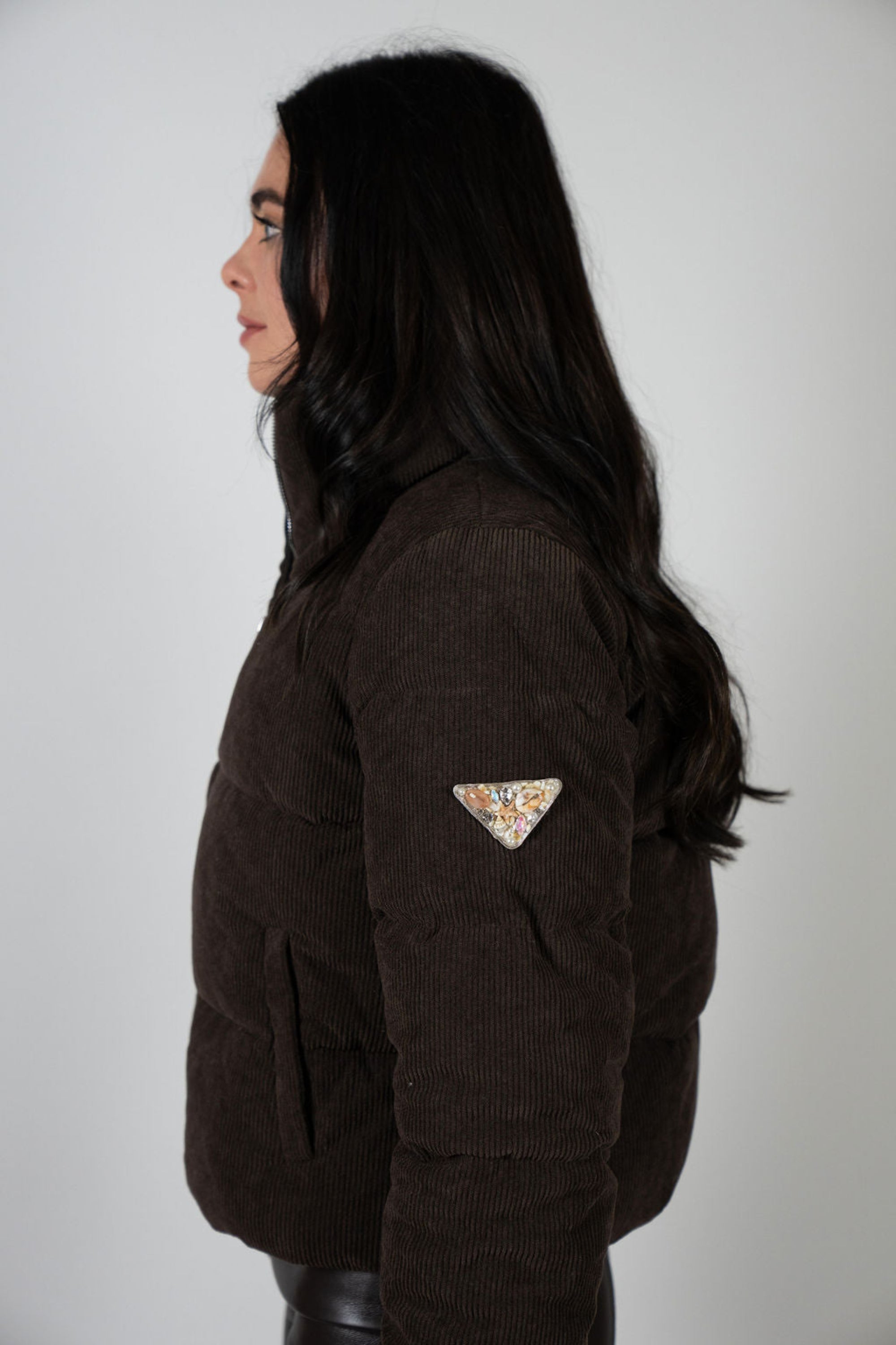 This view shows off the signature embellished triangle patch on the sleeve — a hand-embellished mix of crystals, pearls, and tiny shells that mark the Angel Wings identity.