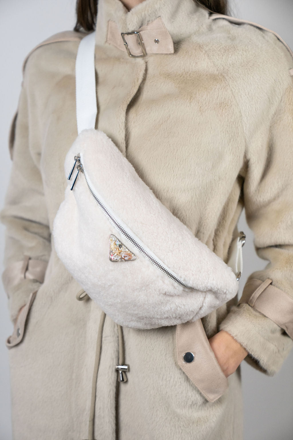 Model wearing the Alpine crossbody bag in Snow by Angel Wings by Lucy, a compact luxury accessory designed for elevated winter and resort wear.