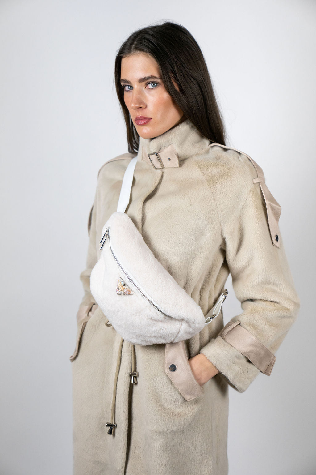 Model wearing the Alpine crossbody bag in Snow by Angel Wings by Lucy, a compact luxury accessory designed for elevated winter and resort wear.