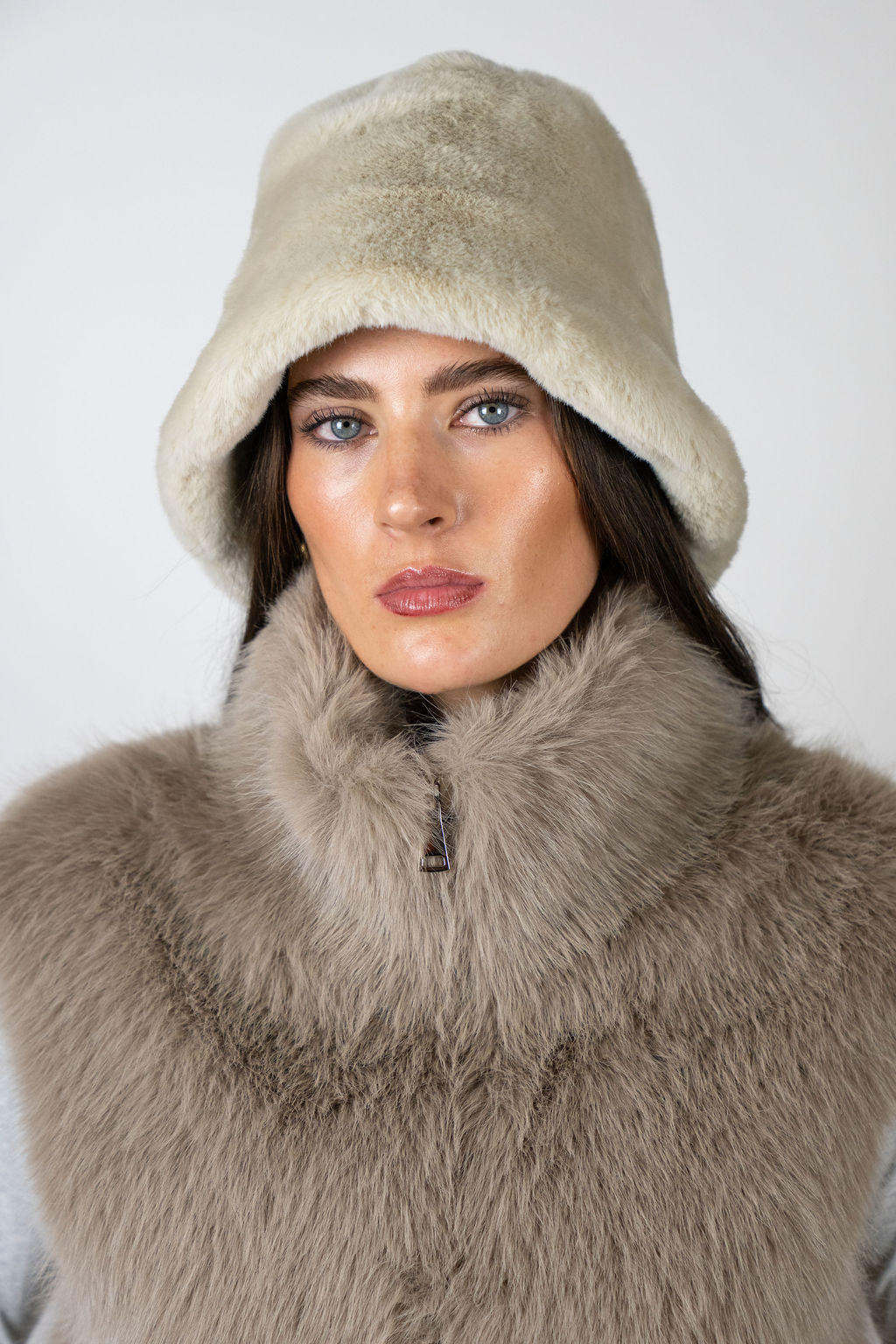 Model wearing the Bucket Hat in Beige by Angel Wings by Lucy, a luxury faux fur accessory designed for elevated winter styling.