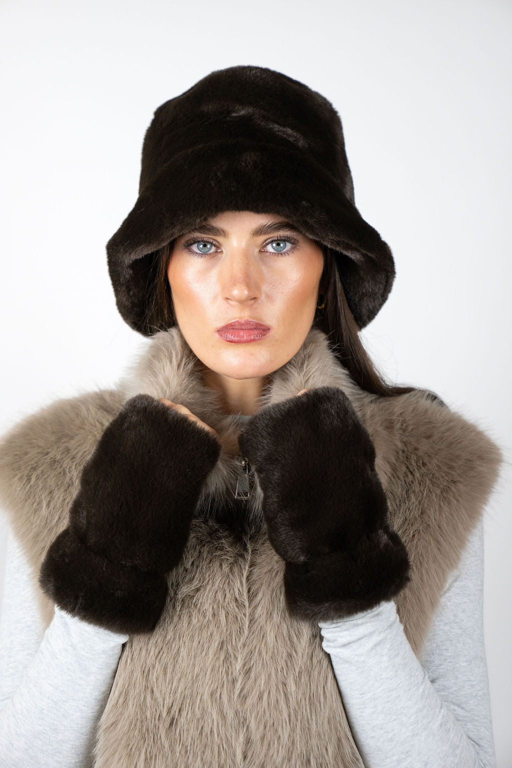 Model wearing Chocolate faux fur gloves by Angel Wings by Lucy, styled with a faux fur vest for elevated winter and luxury resort dressing.