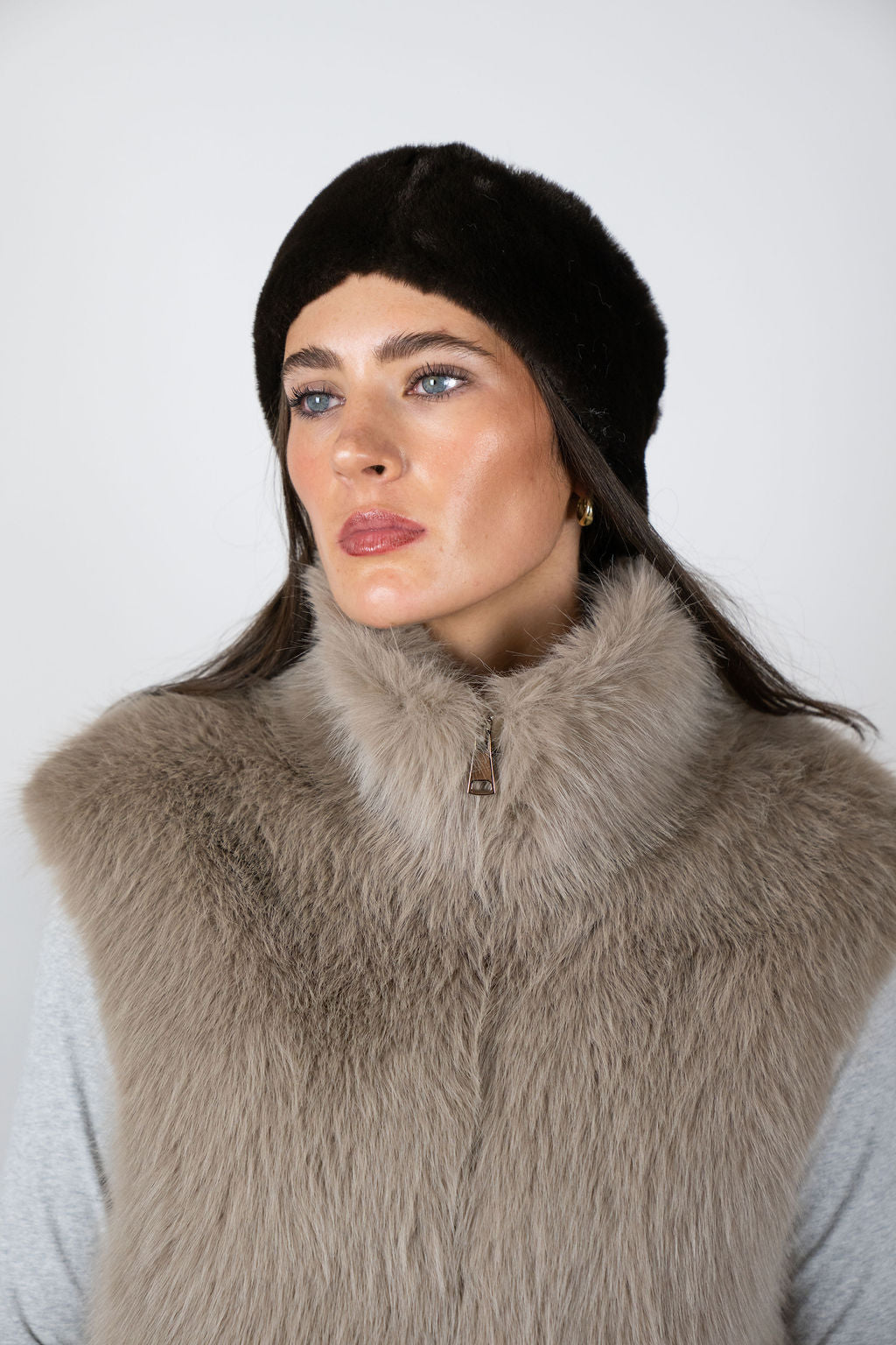 Model wearing the faux fur headband in Chocolate by Angel Wings by Lucy, styled with a faux fur vest for elevated winter accessorising.