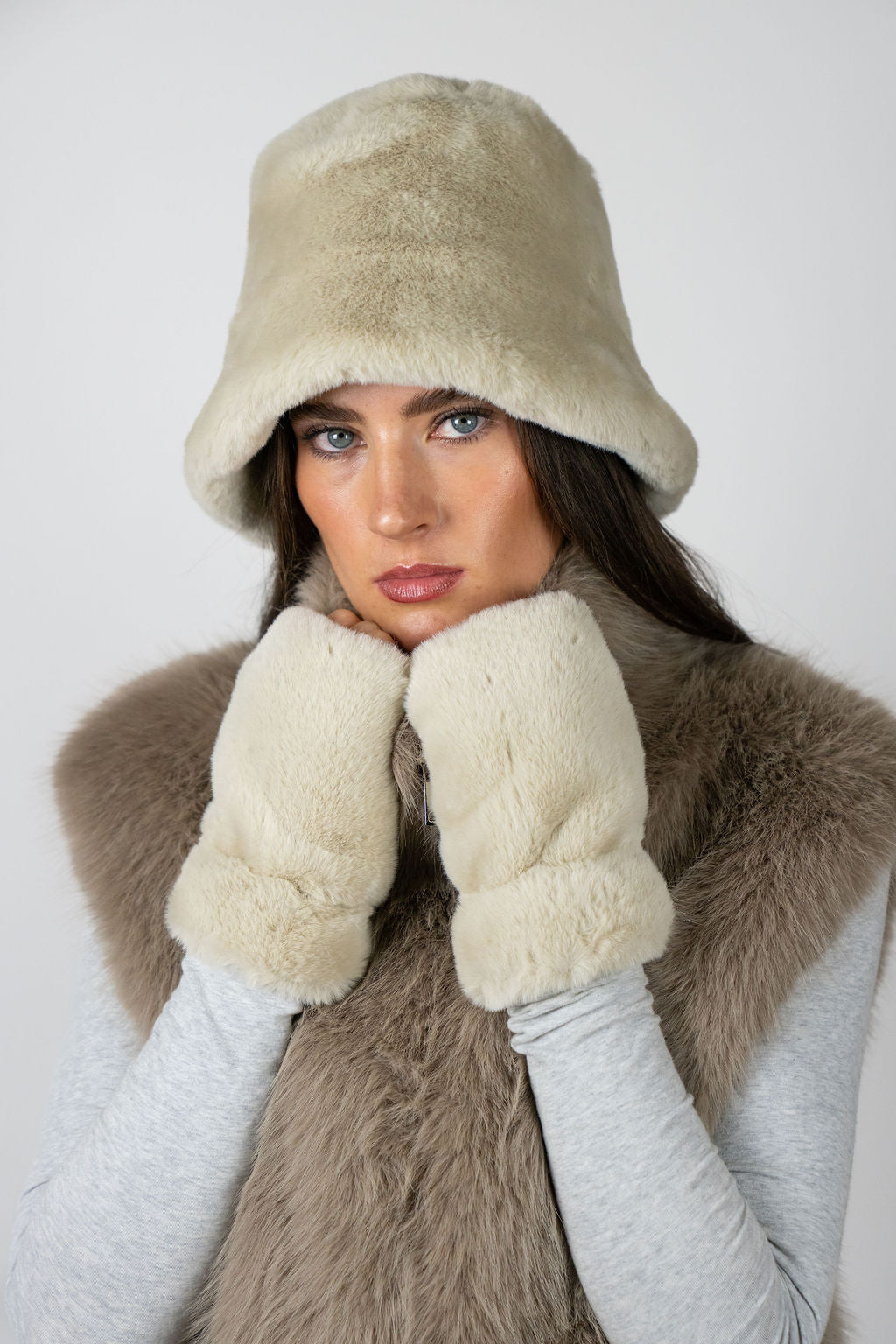 Model wearing fingerless faux fur gloves in Beige by Angel Wings by Lucy, styled with a faux fur vest for elevated winter layering.