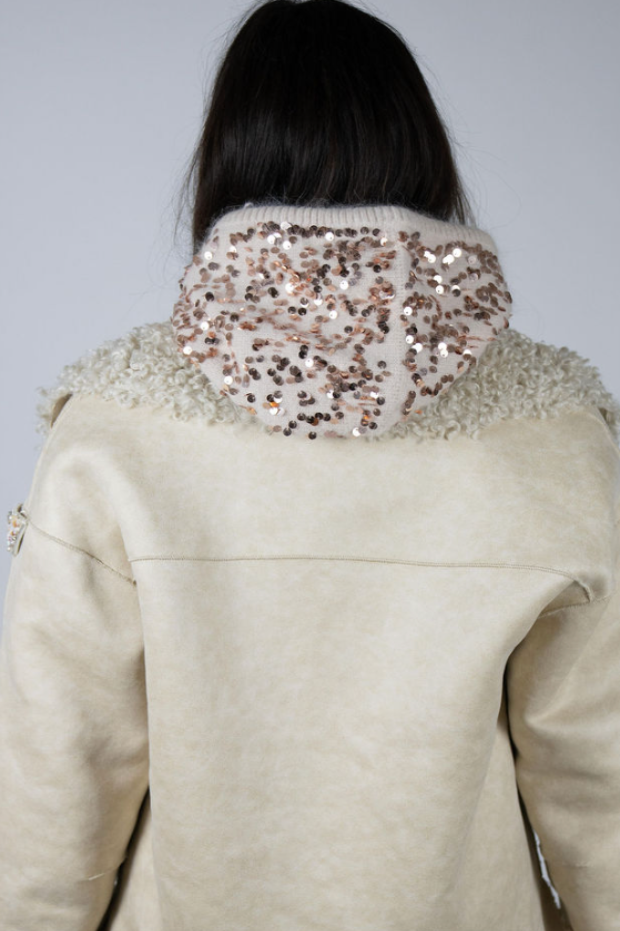Model wearing the Sequin Knit Hood in Beige by Angel Wings by Lucy, a luxury knit hood with subtle sequin detailing designed for elevated winter and resort styling.