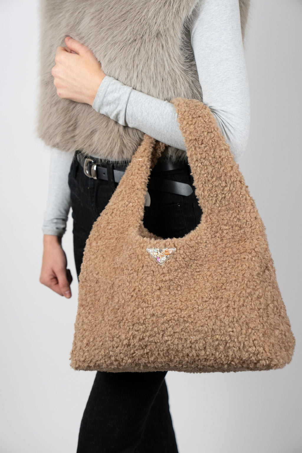 Model wearing The Cloud Club bag in Beige by Angel Wings by Lucy, a plush luxury handbag designed for elevated winter and resort styling.