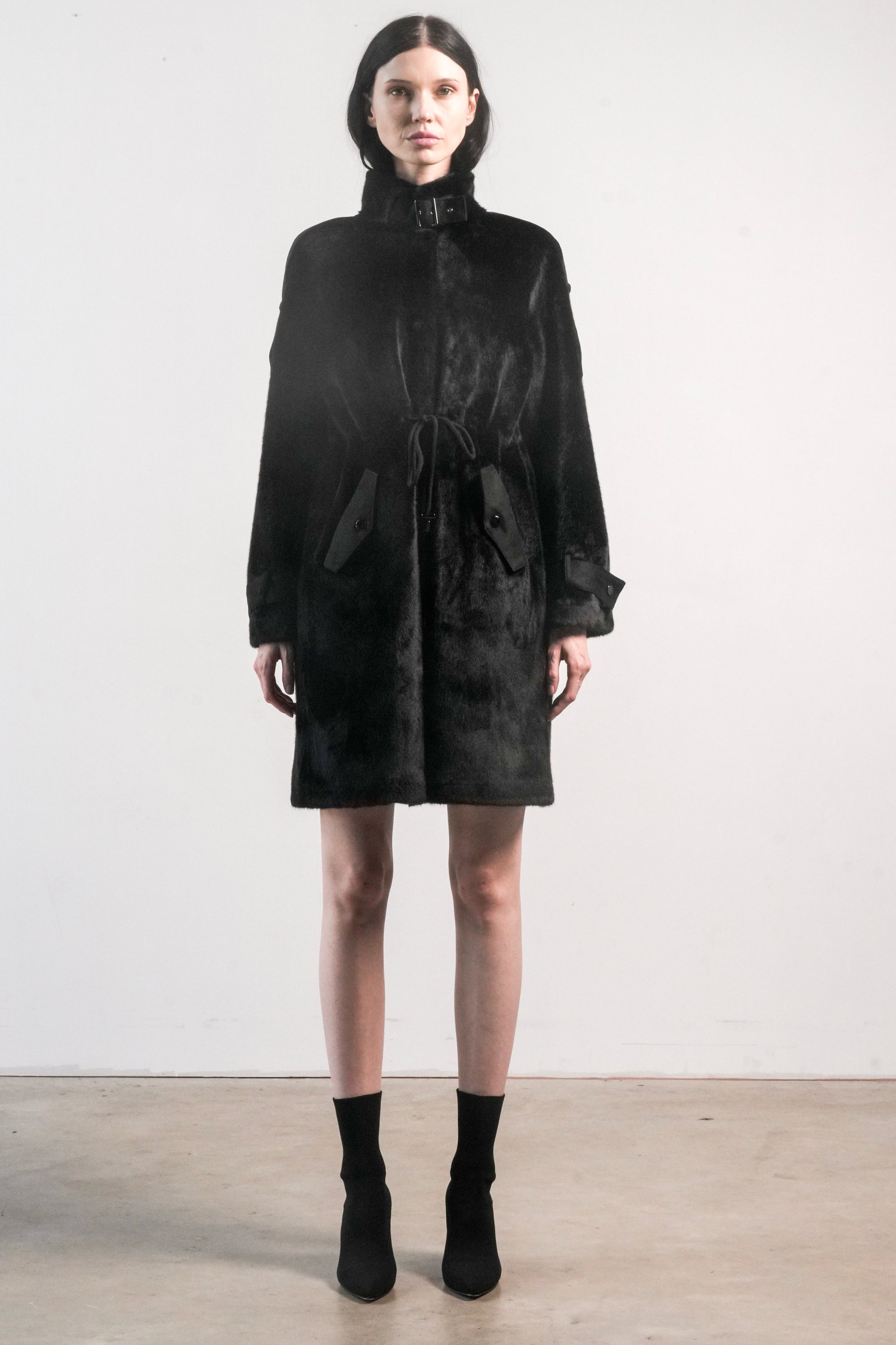 Front view of black faux fur jacket with high collar, drawstring waist, and tonal suede trim — Chica Chica style in Black.