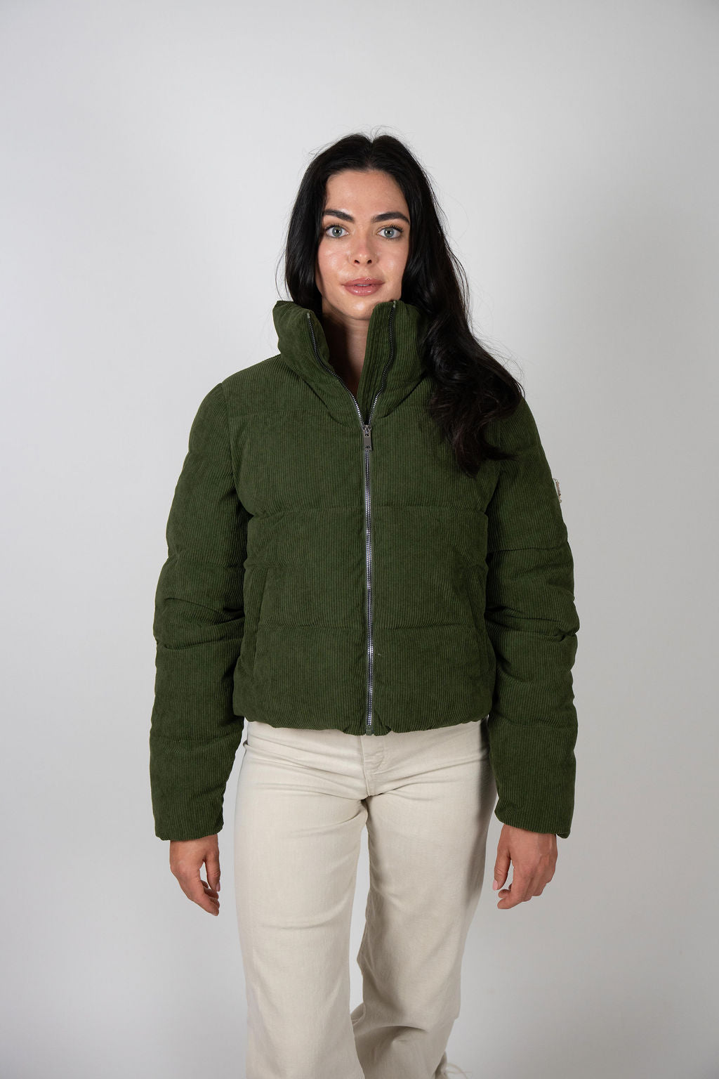 Woman wearing the Angel Wings Sundeck Jacket in olive green with cream pants, facing forward