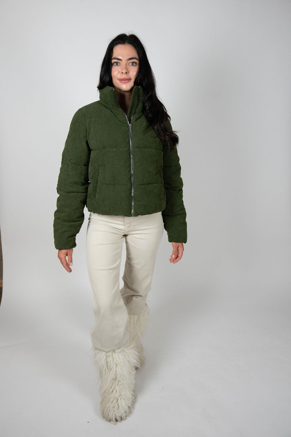 Model walking in olive Sundeck Jacket wearing cream fuzzy boots