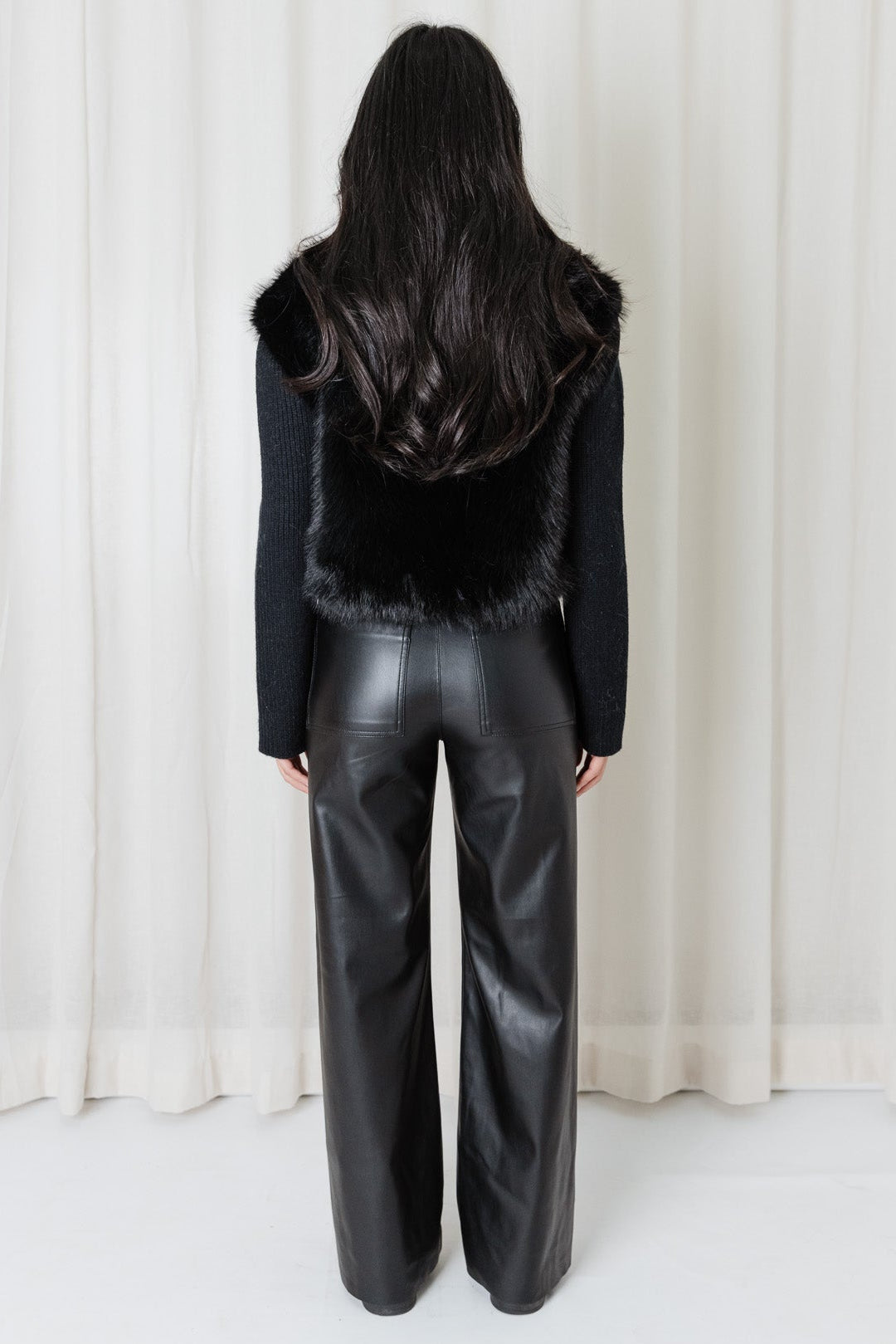 Back view of the Angel Wings Snow Angel Knit in Black with faux-fur body and long knit sleeves.
