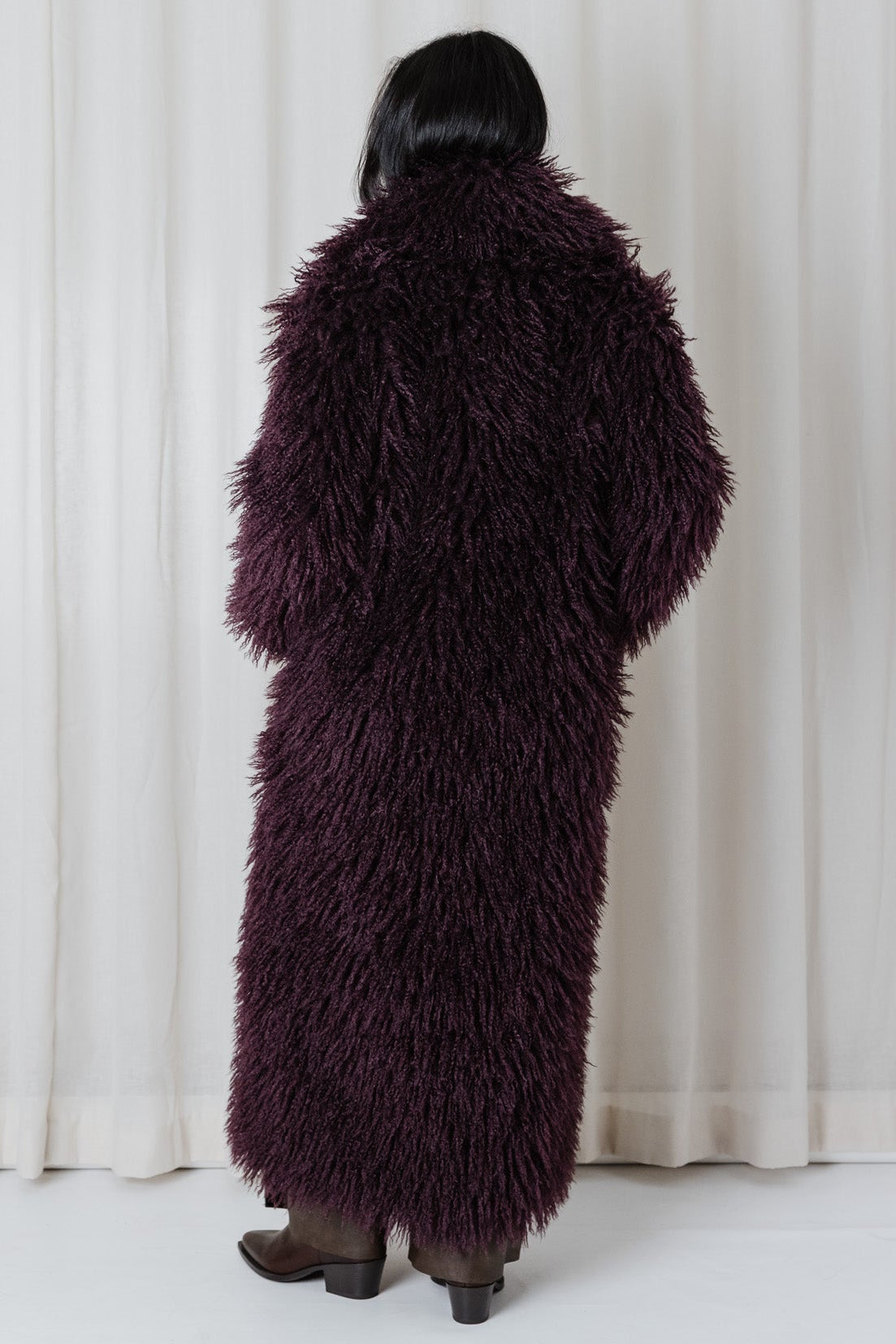 Back view of the Angel Wings Yeti Coat in Bordeaux showing its long oversized shaggy faux-fur silhouette