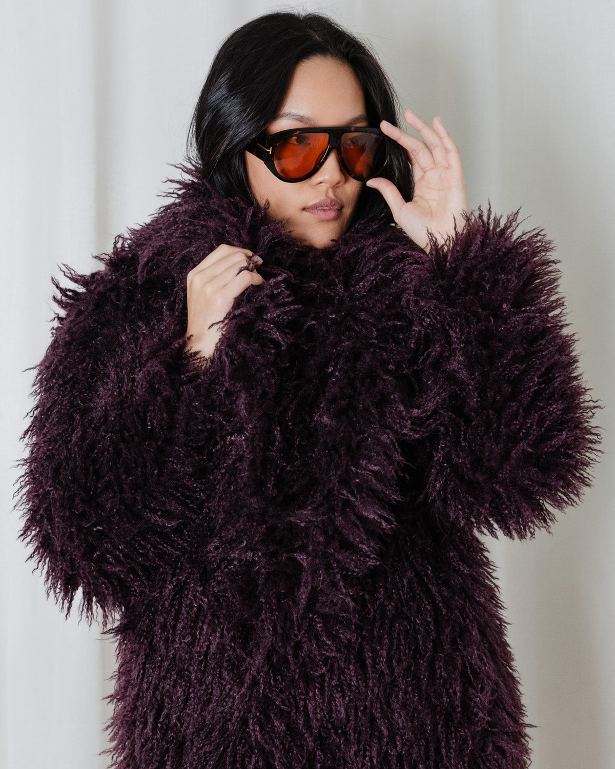 Crop view of the Angel Wings Yeti Coat in Bordeaux, a long shaggy faux-fur statement coat.