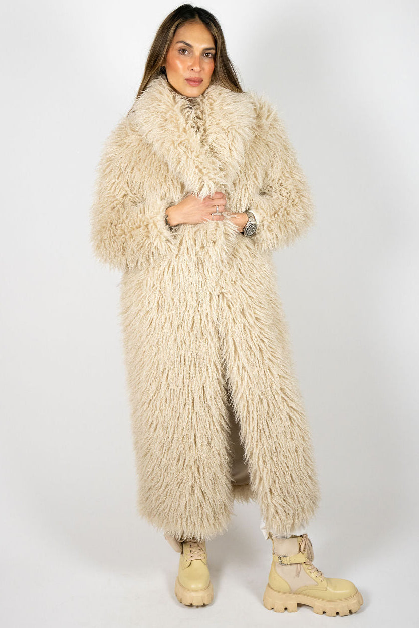 Model wearing the Angel Wings Yeti Coat in Oat, a long shaggy faux-fur statement coat.